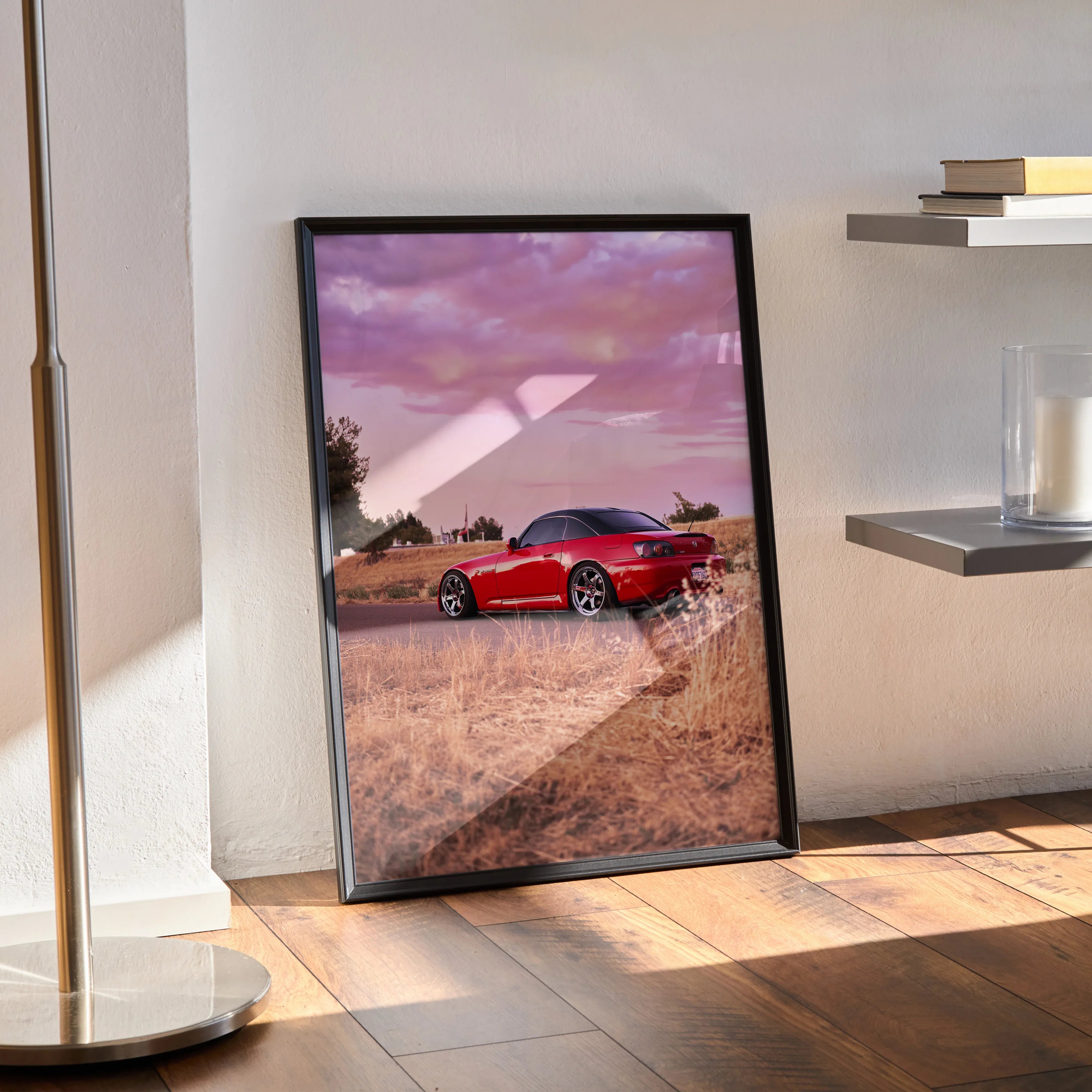 Honda S2000 red sports car poster with a purple sunset sky, framed wall art leaning on floor.