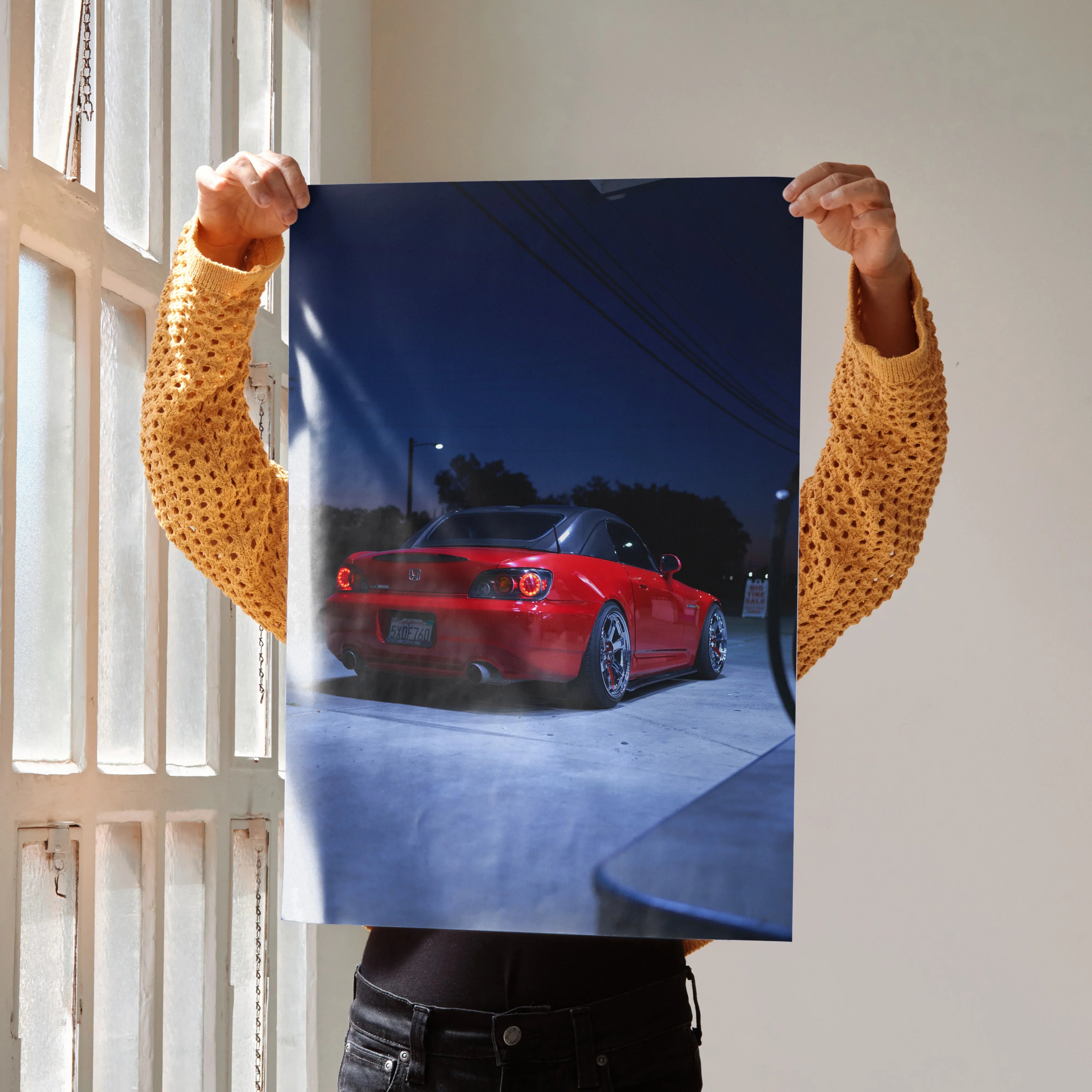 Honda S2000 red sports car poster held as sleek automotive wall art against a dark blue night sky.