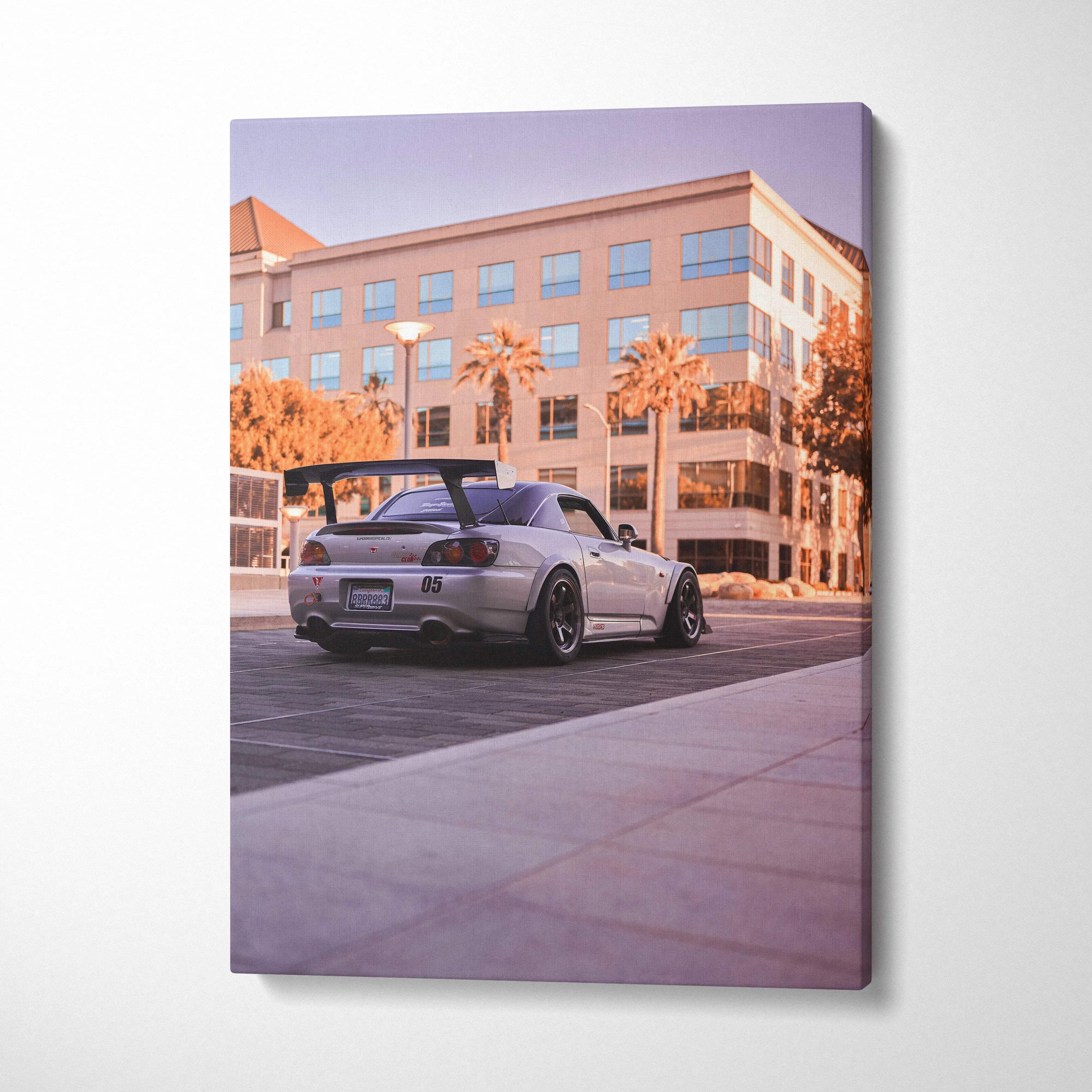Canvas wall art of a sleek silver honda s2000 with black rear spoiler and custom wheels in warm sunset purple hues