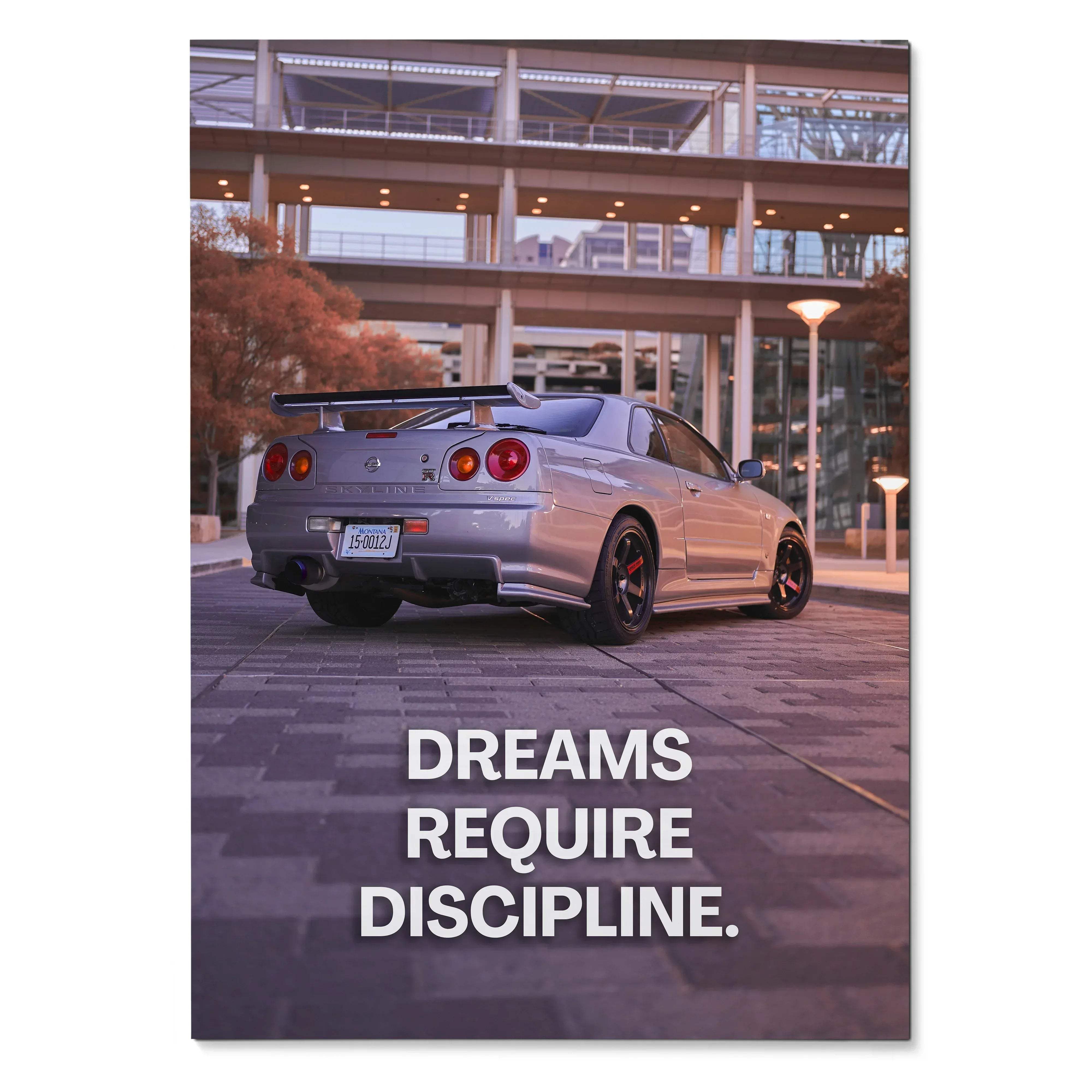 Nissan GT-R R34 Skyline parked at night with inspiring text "Dreams Require Discipline" poster wall art.