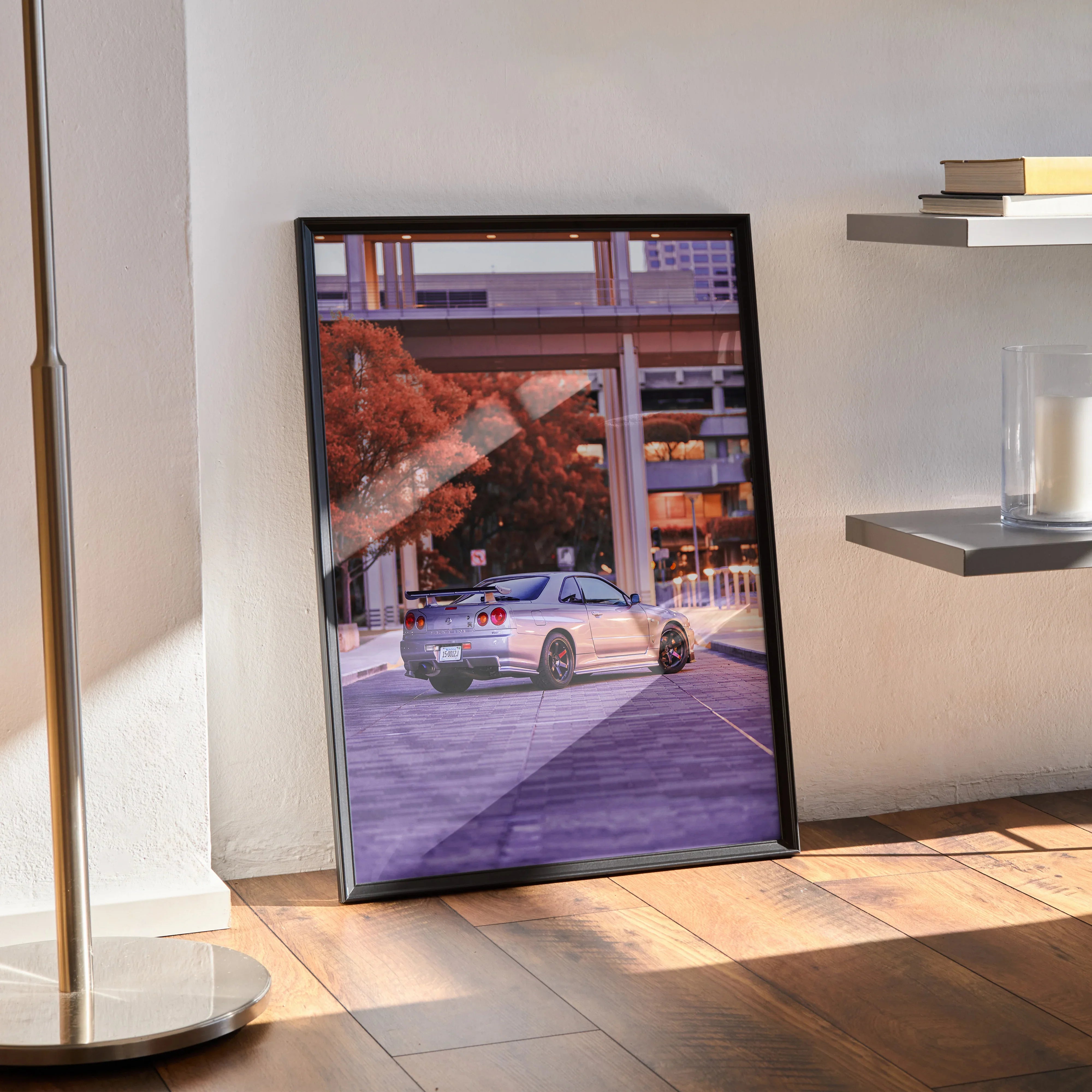 Nissan GTR R34 Skyline poster with urban background in black frame leaning on floor wall art.