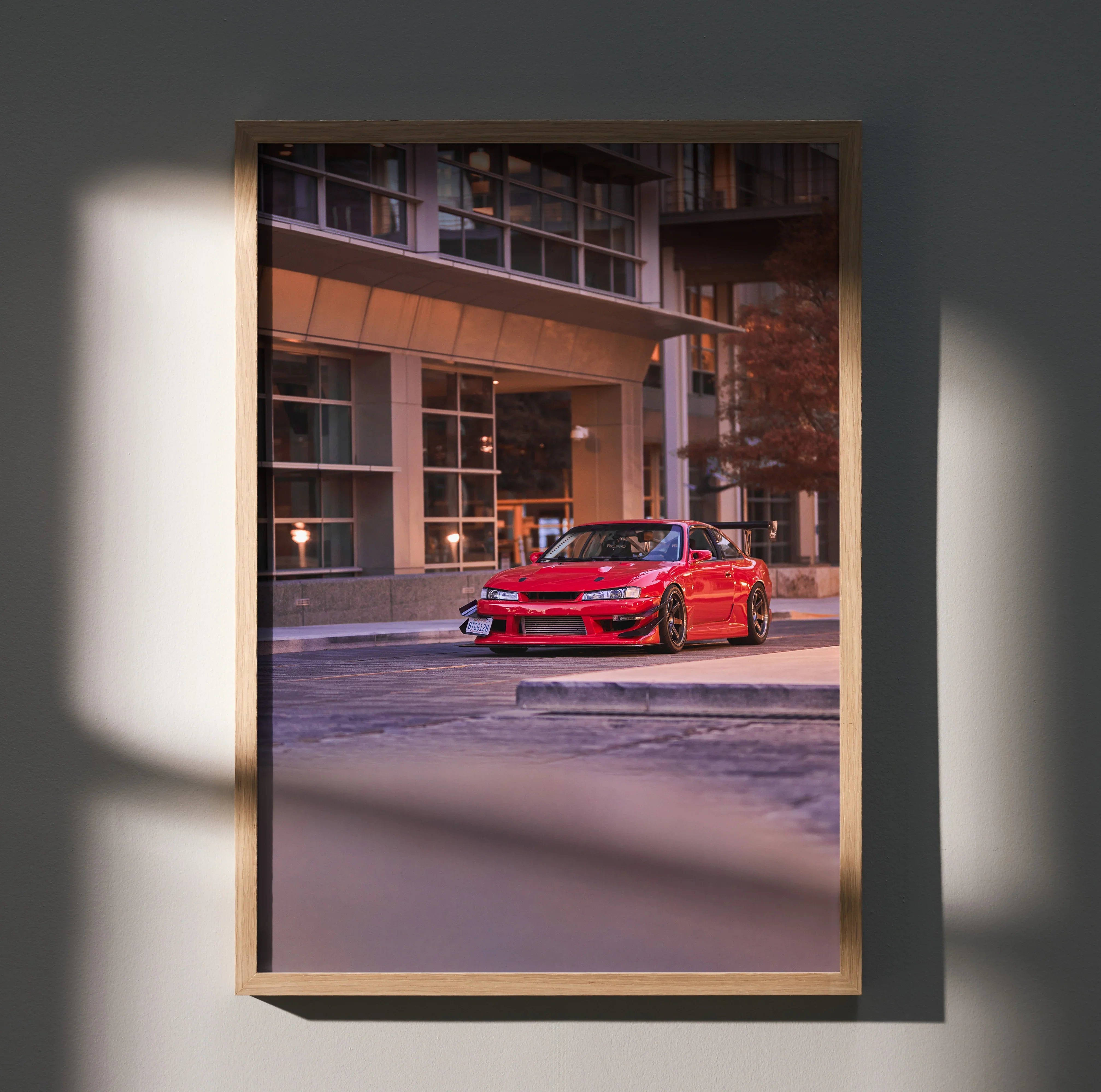 Red Nissan 240sx S14 Kouki parked in urban setting poster wall art with modern building backdrop.