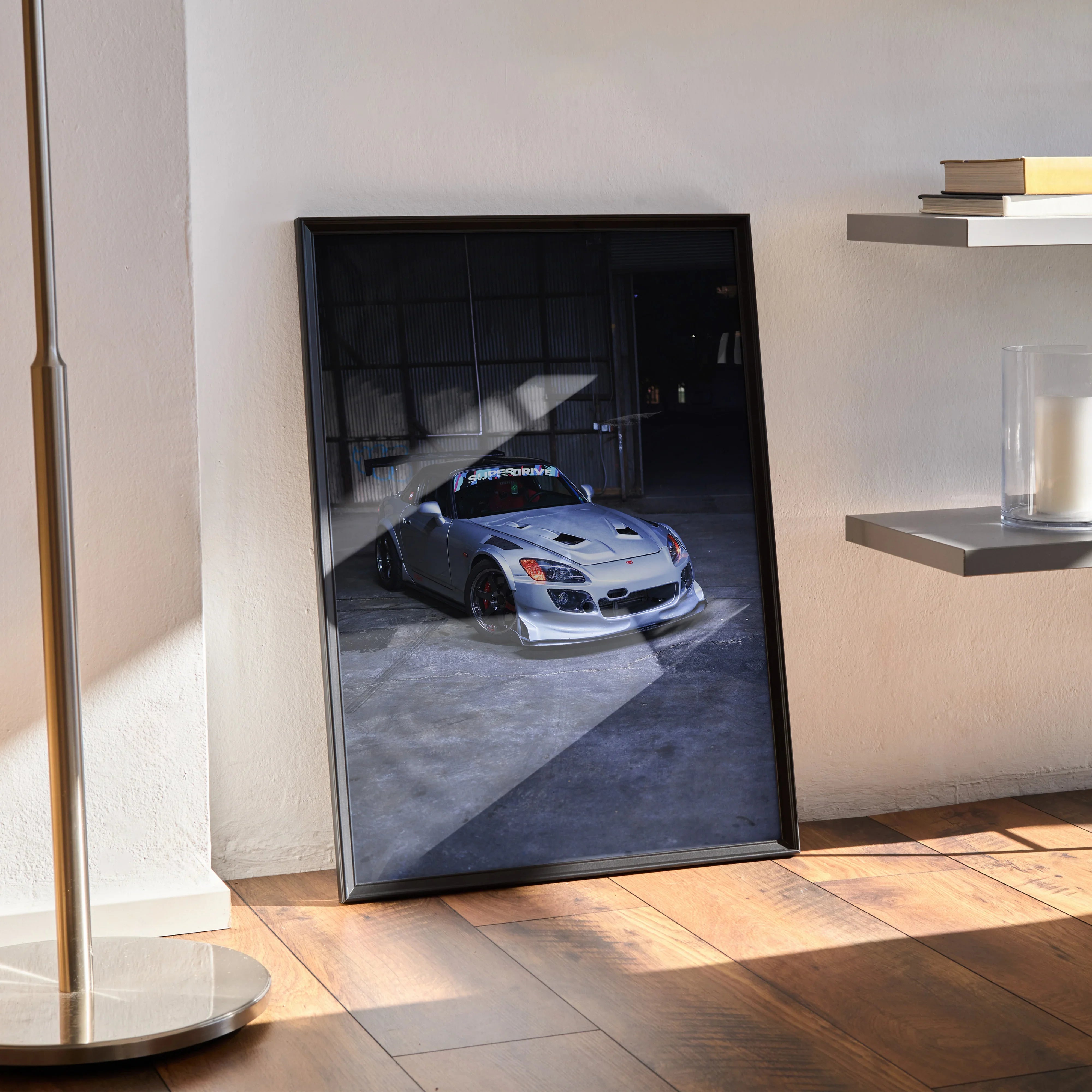 Honda S2000 poster wall art showing a sleek silver sports car in a shadowed garage setting.