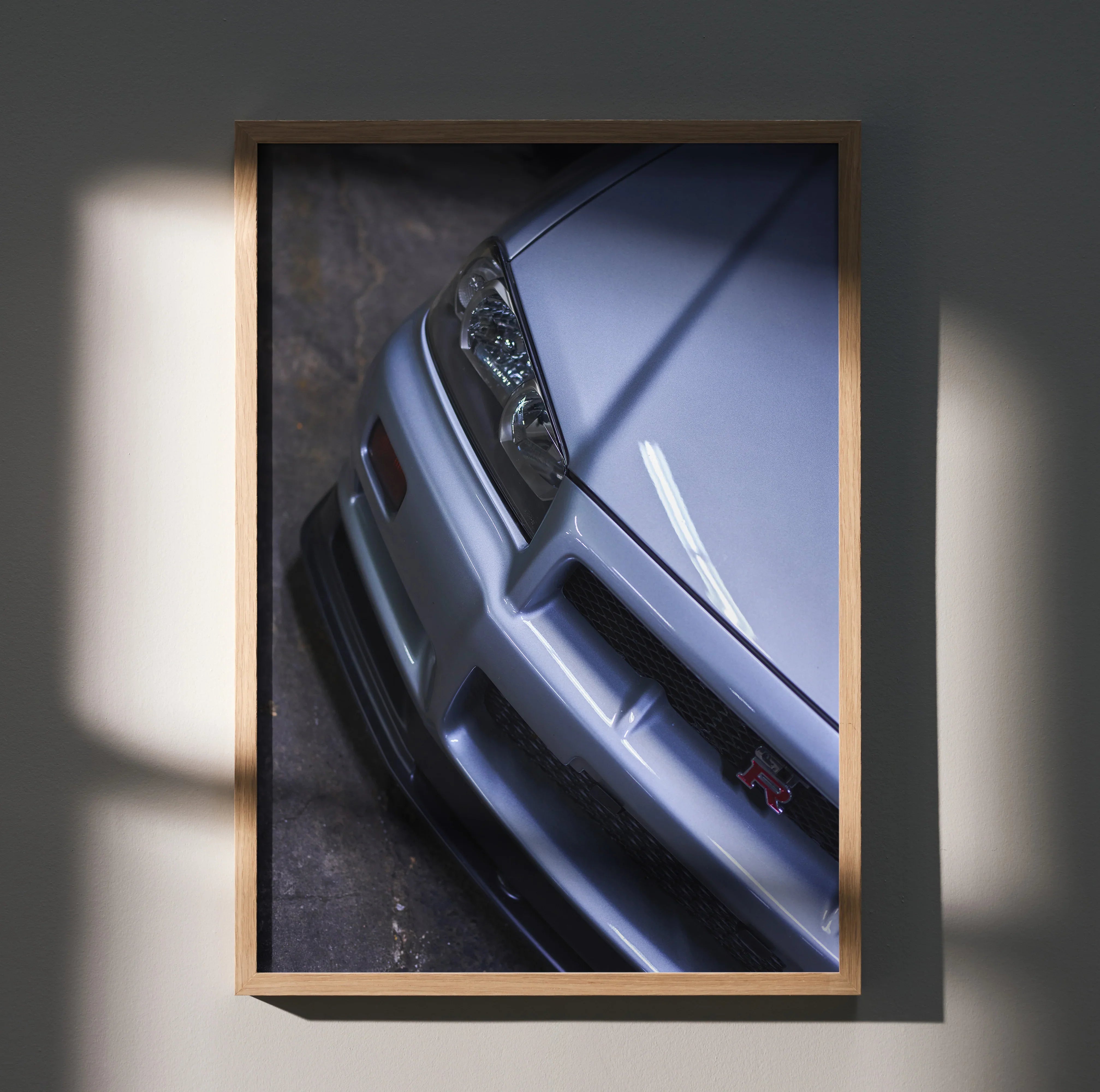 Nissan R34 GTR Skyline close-up poster showcasing front bumper and headlight in sleek silver wall art.
