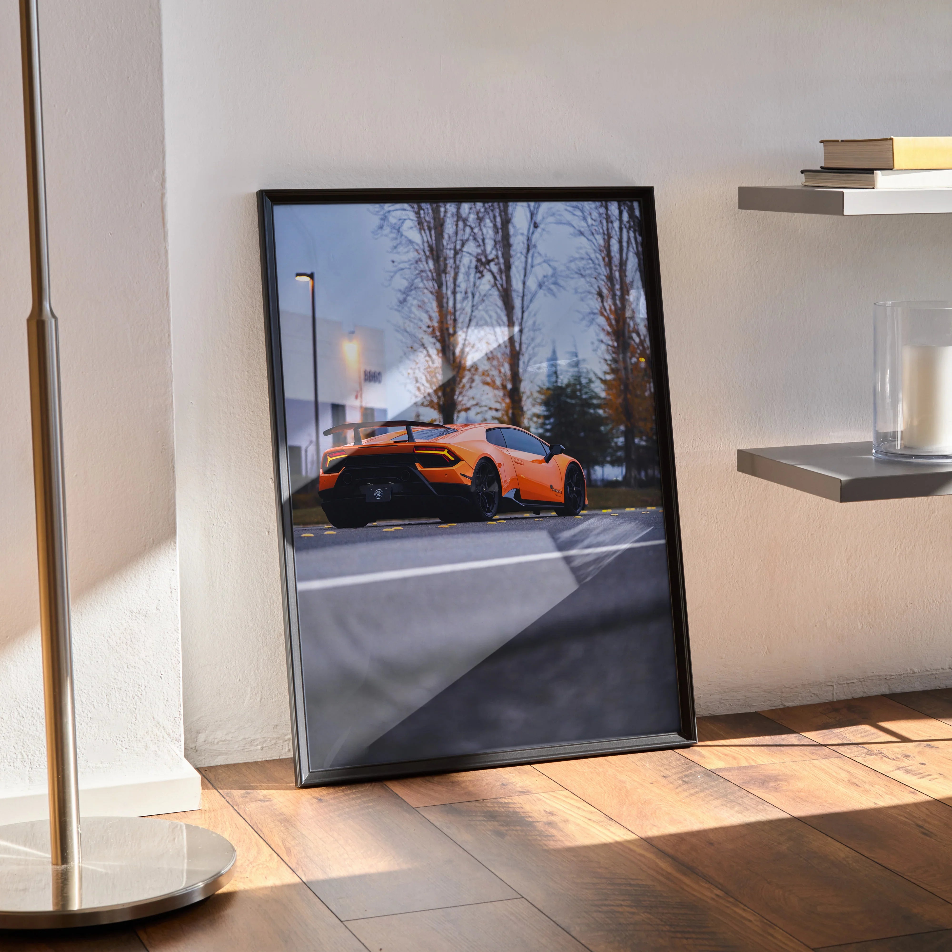 Lamborghini Huracan orange sports car poster leaning on floor luxury wall art with trees and streetlamp background.