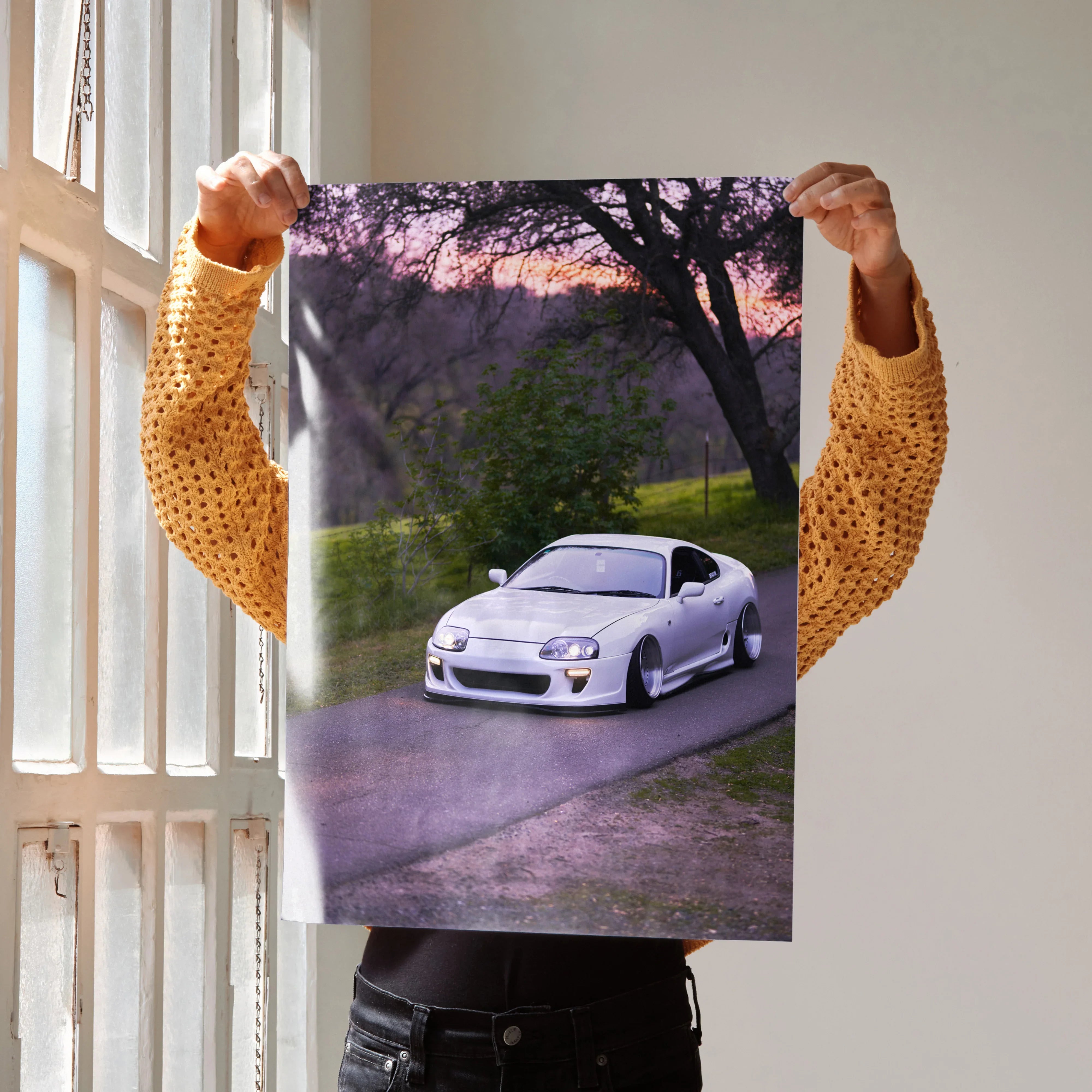 Toyota Supra MK4 driving on sunset road poster wall art with purple sky backdrop.