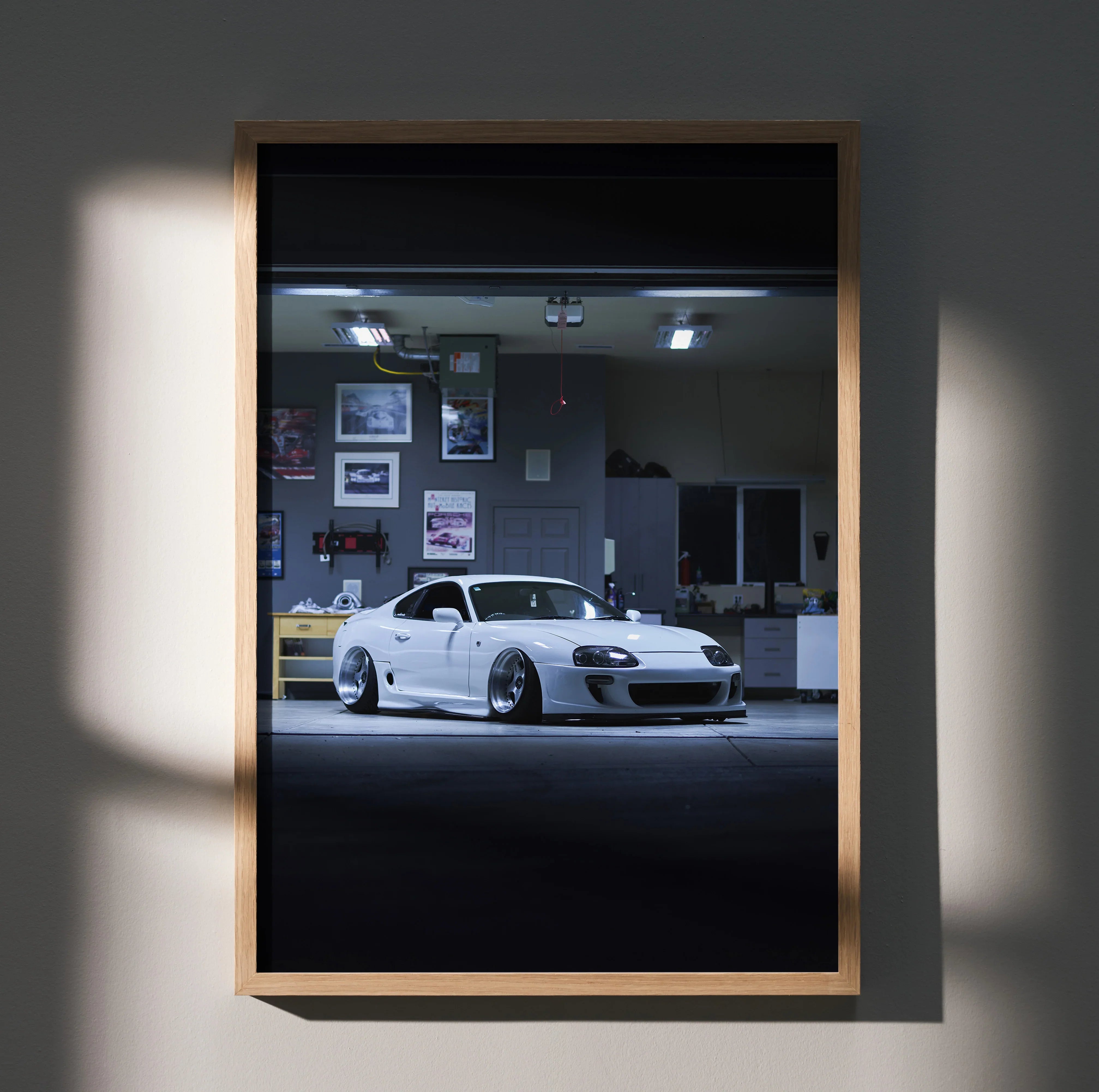 Toyota Supra MK4 white sports car poster in a framed wall art with garage background.