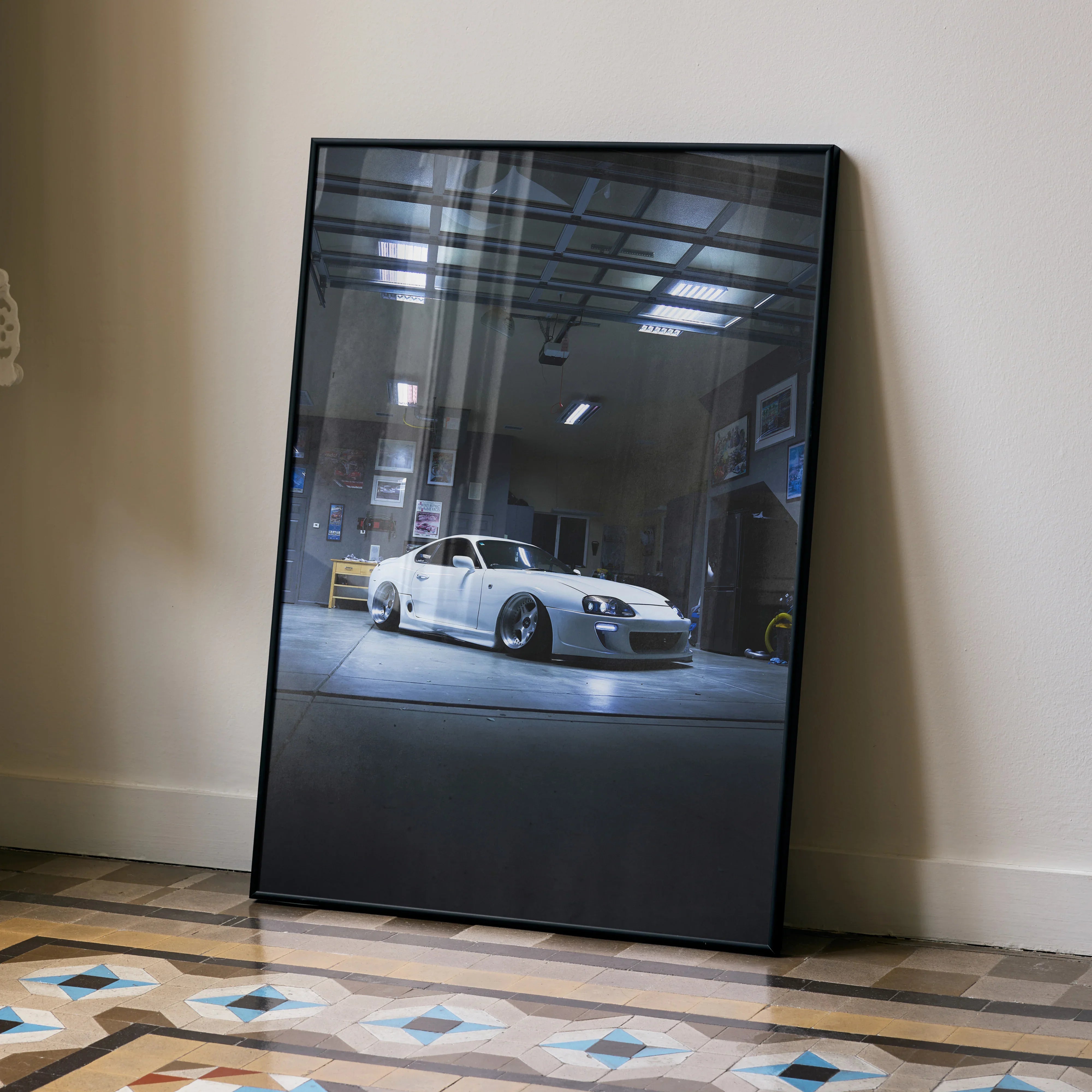 Toyota Supra MK4 parked indoors with dramatic lighting poster wall art in black frame.
