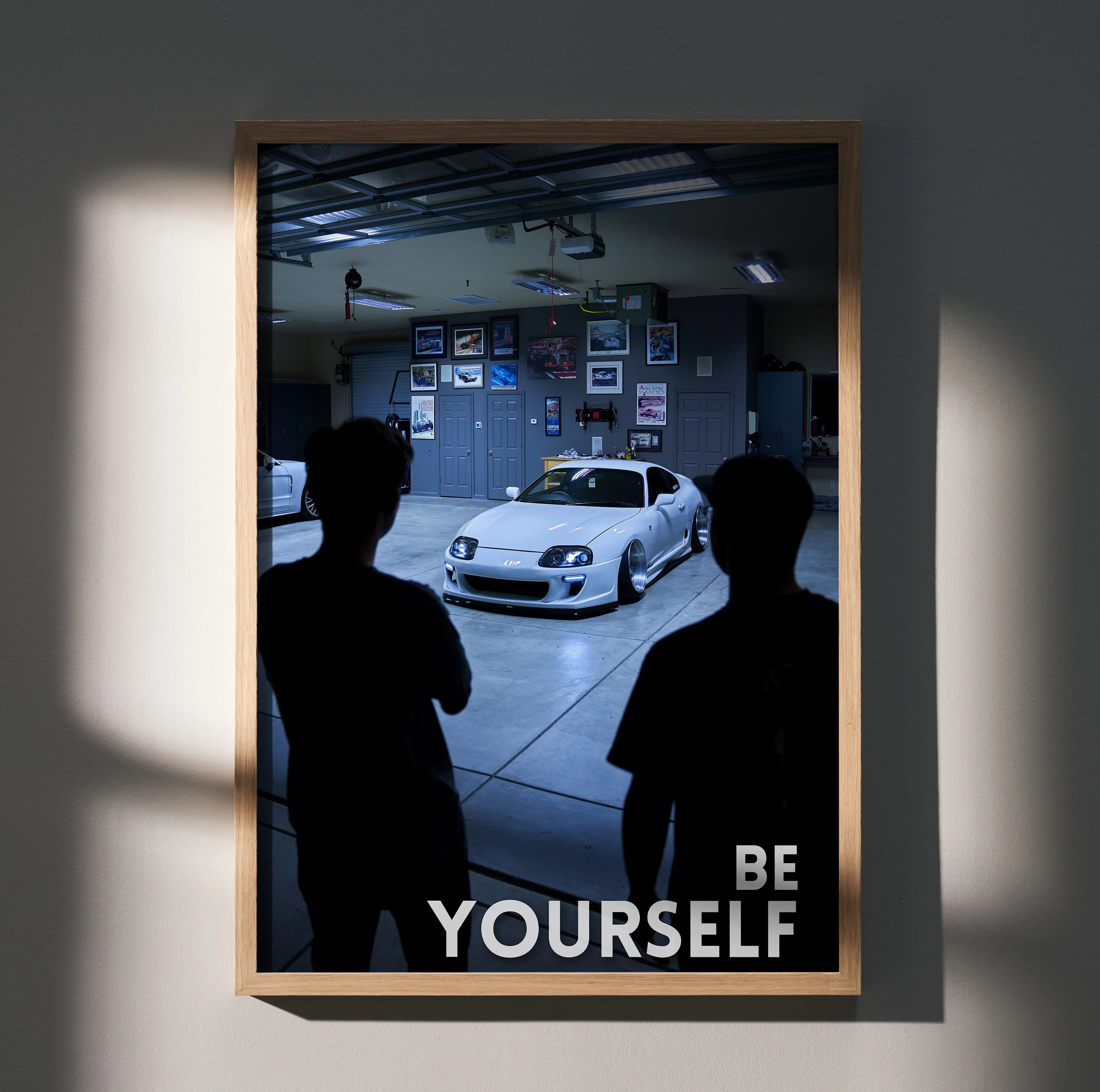 Motivational poster featuring white Toyota Supra Mk4 in garage with "Be Yourself" text wall art.