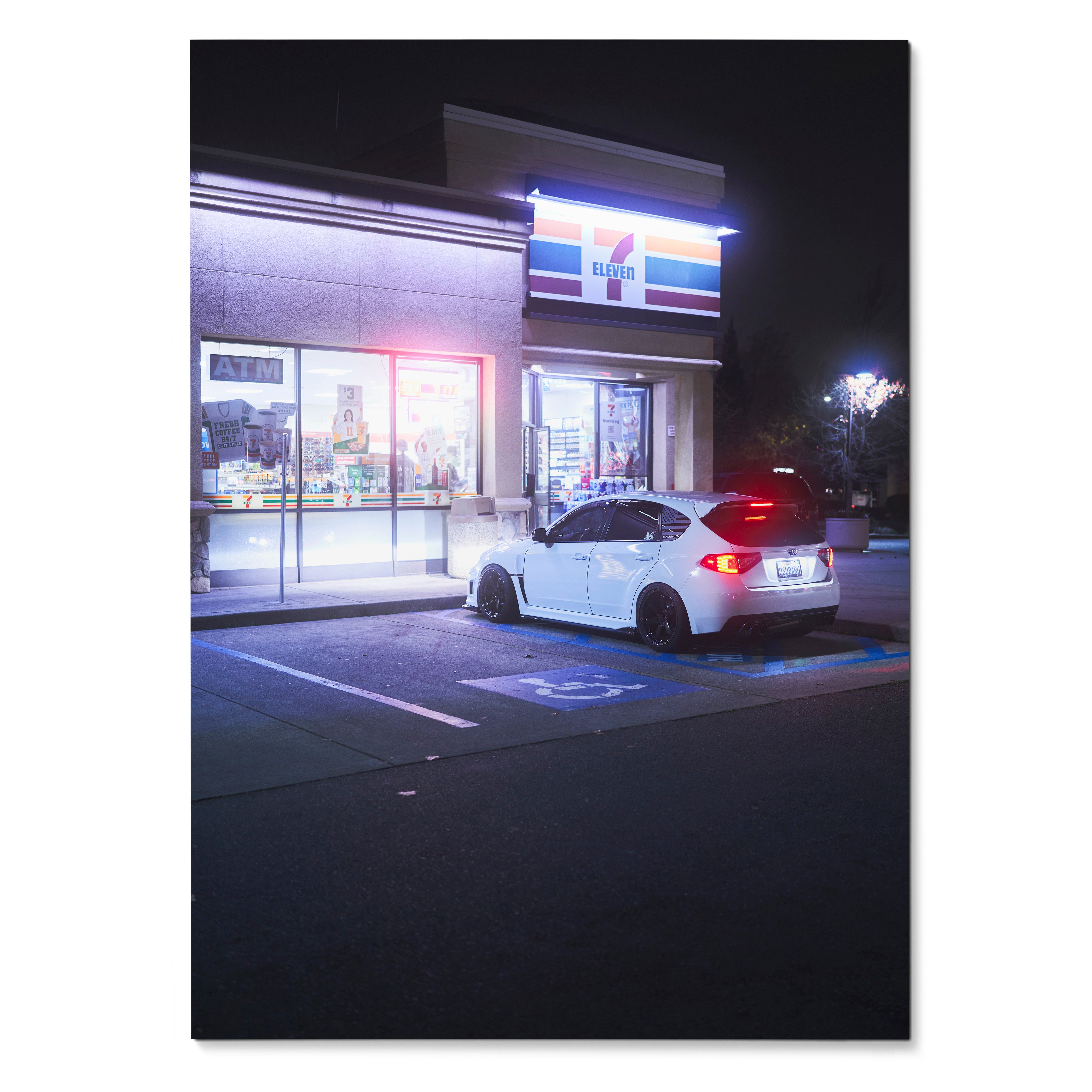 White Subaru WRX STI parked outside illuminated 7-Eleven at night poster wall art.