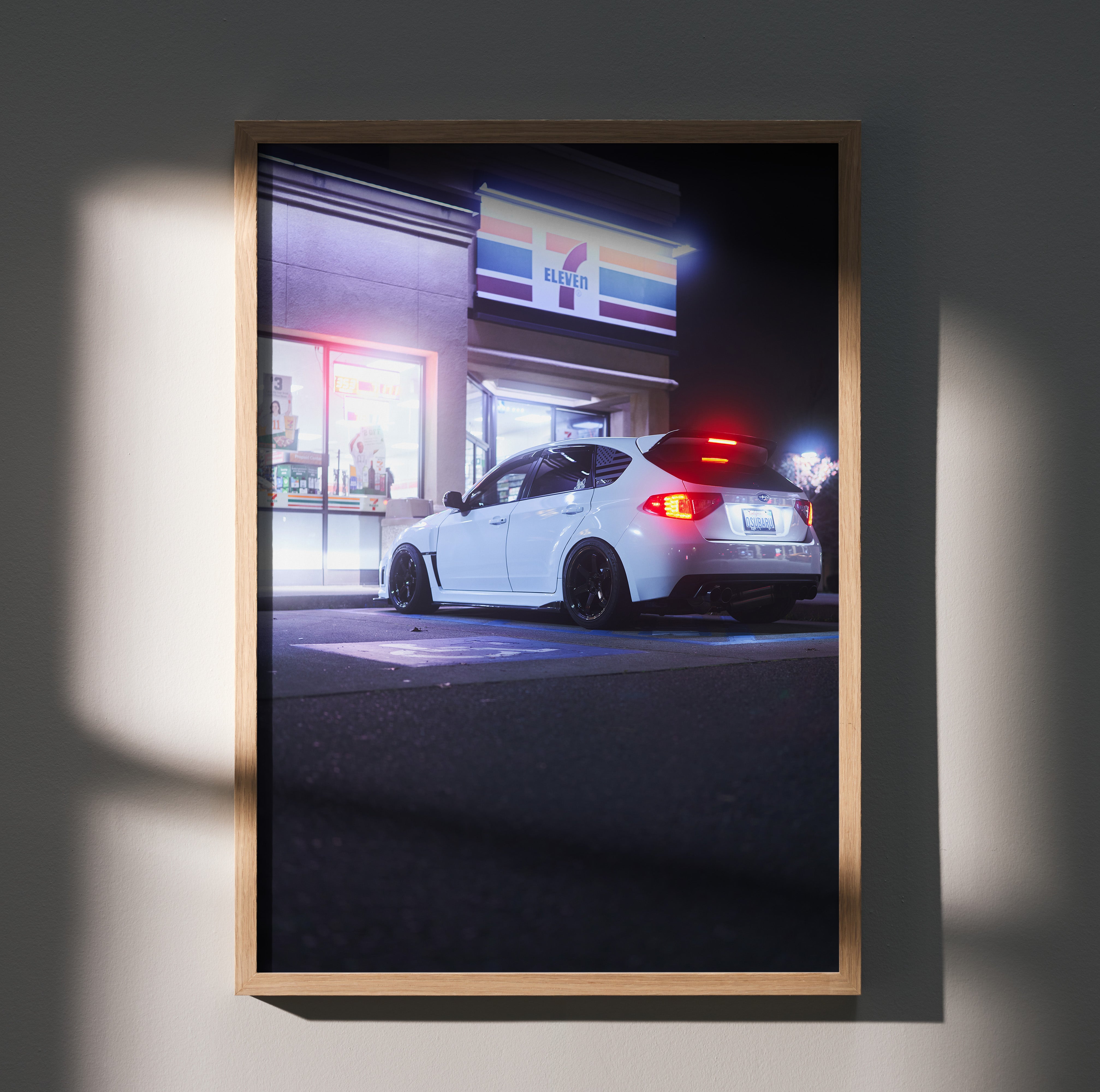 Subaru WRX STI parked outside 7-Eleven at night poster wall art with glowing taillights.