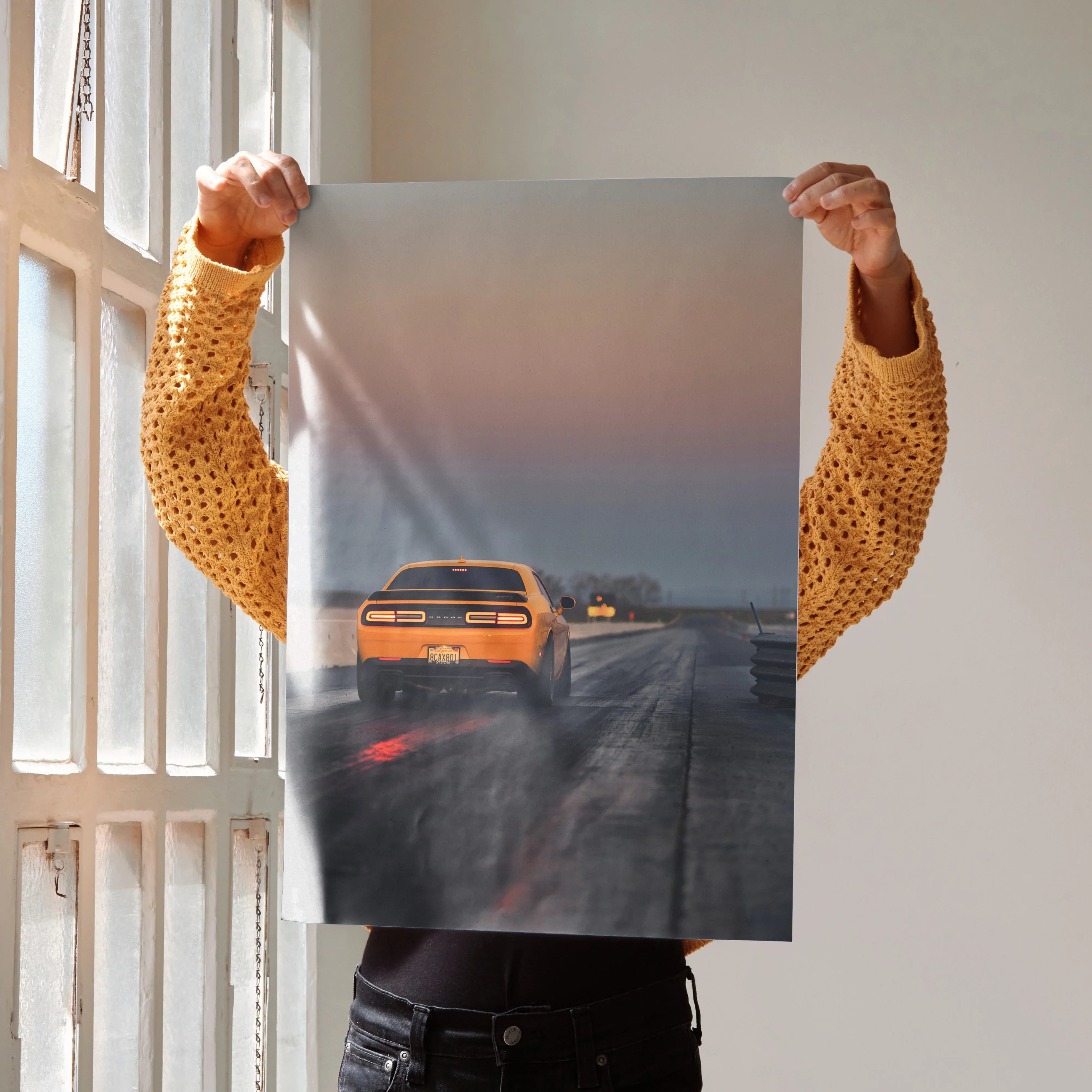 Dodge Challenger poster showing rear view of orange muscle car on rainy road, automotive wall art.