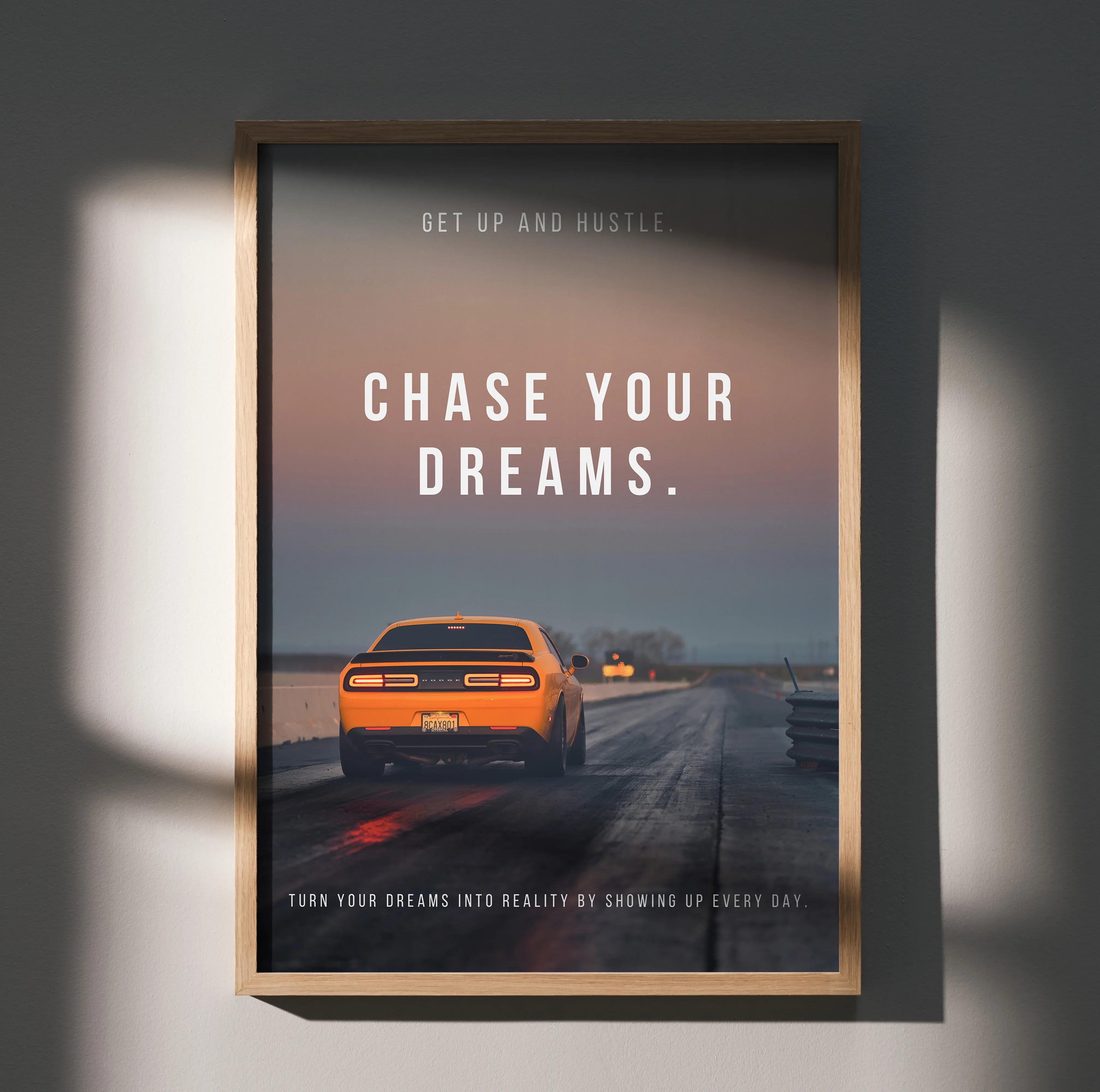 Motivational poster wall art with orange Dodge Challenger on road and "Chase Your Dreams" text.