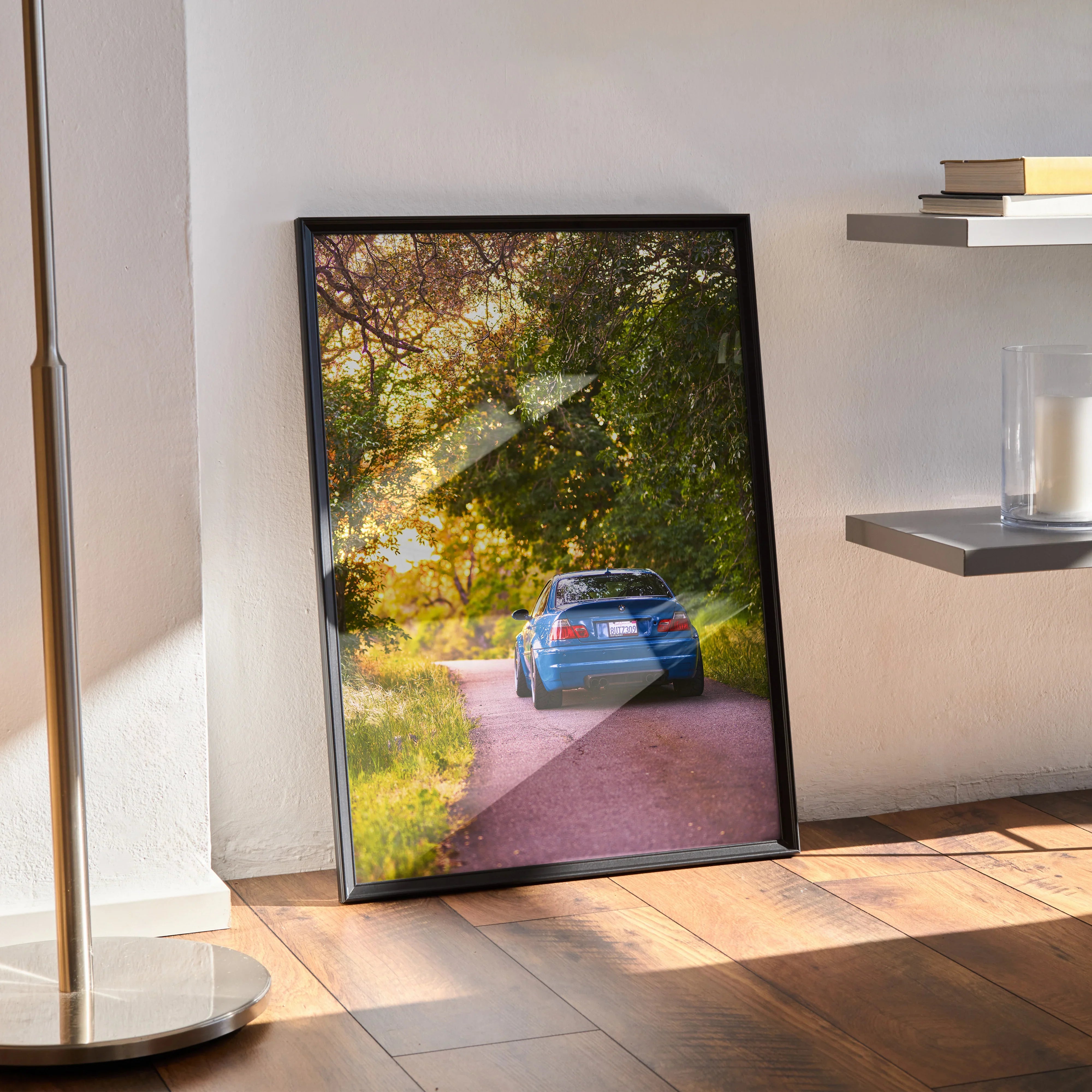 BMW E46 M3 poster featuring a vibrant blue car on a sunlit forest road wall art piece.