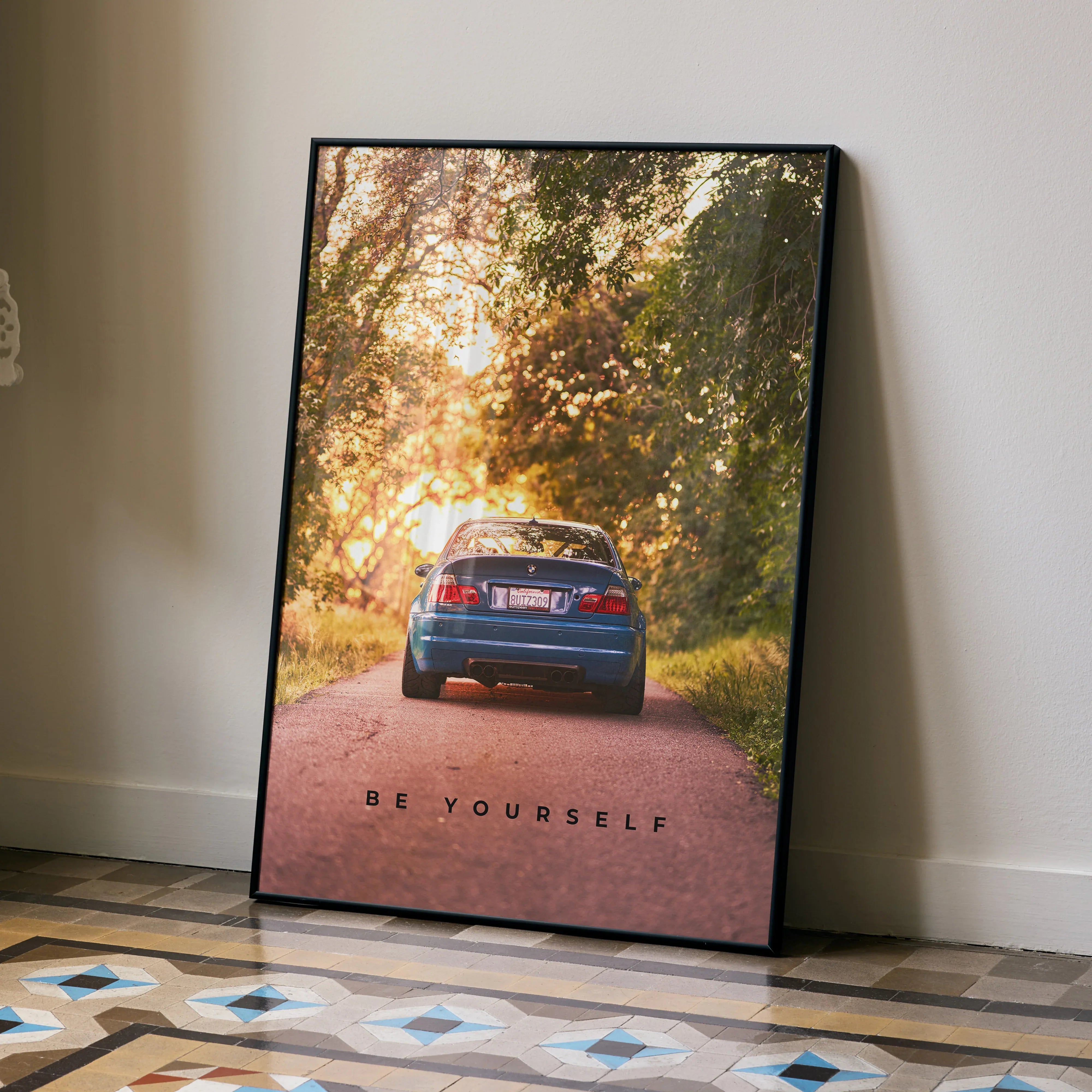 Motivational poster wall art featuring BMW E46 M3 rear view on tree-lined road with "Be Yourself" text.