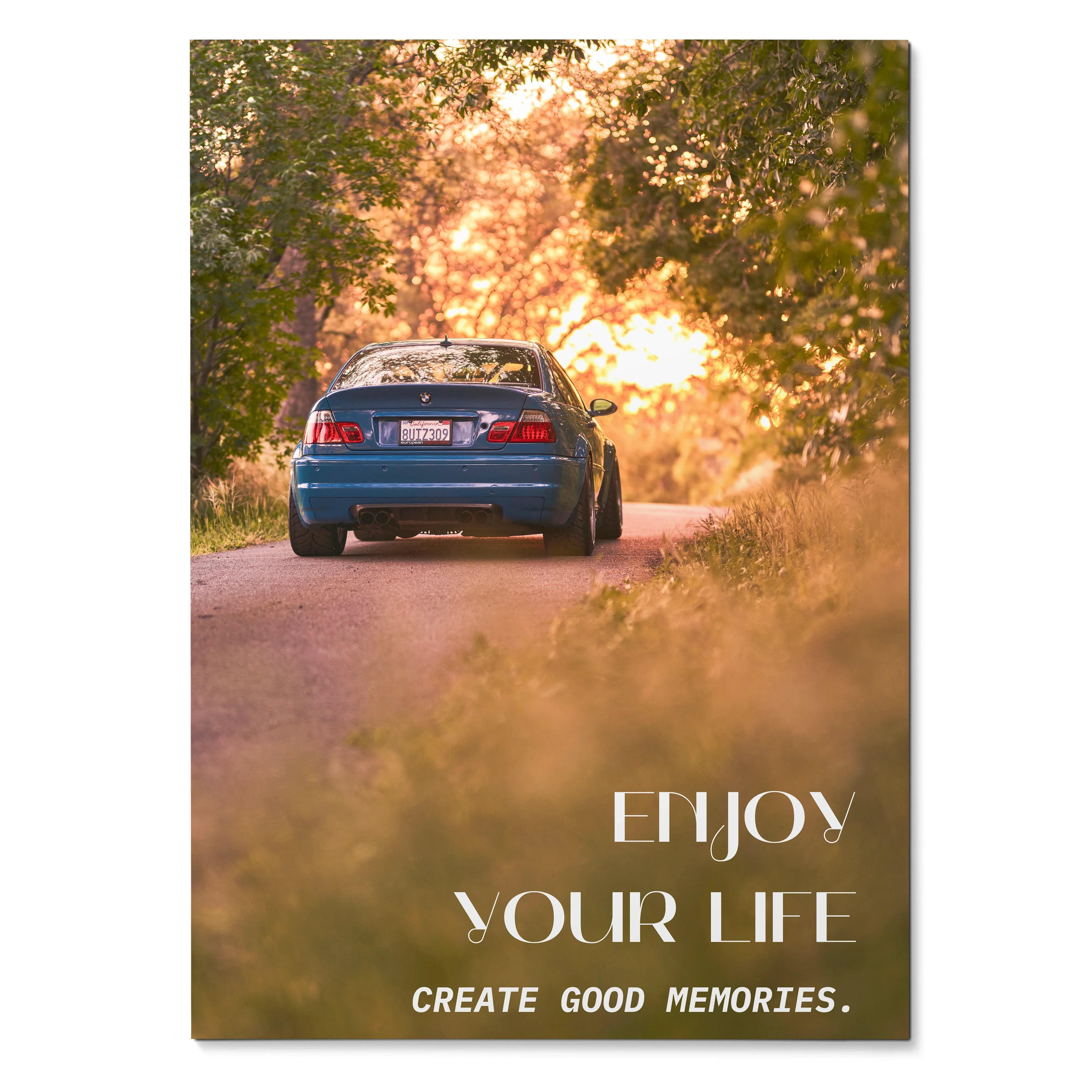 Motivational poster wall art featuring rear view of blue BMW E46 M3 on sunlit forest road with inspiring text.