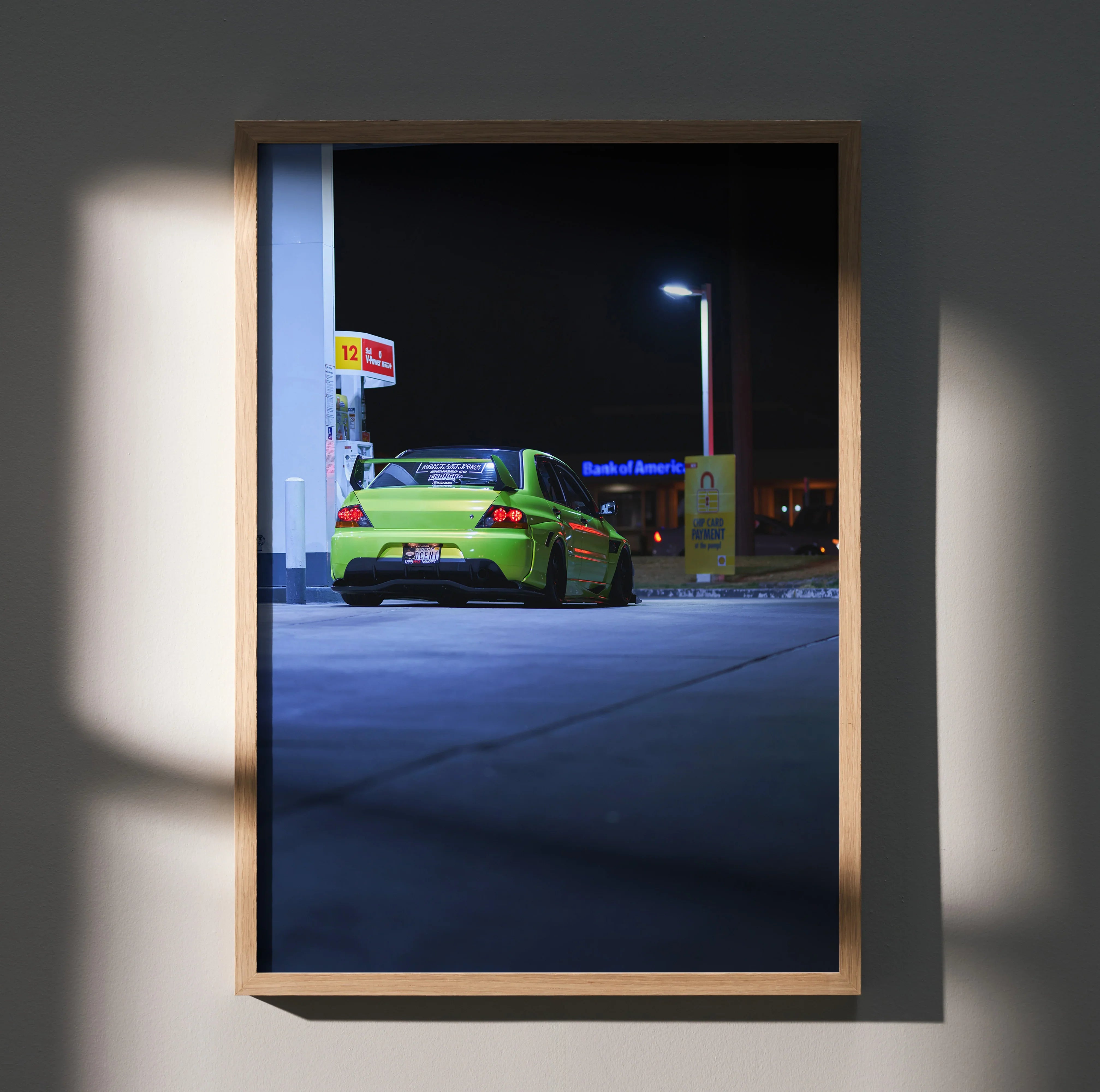 Poster wall art featuring a green Mitsubishi Evo 9 parked at a nighttime gas station under streetlights.