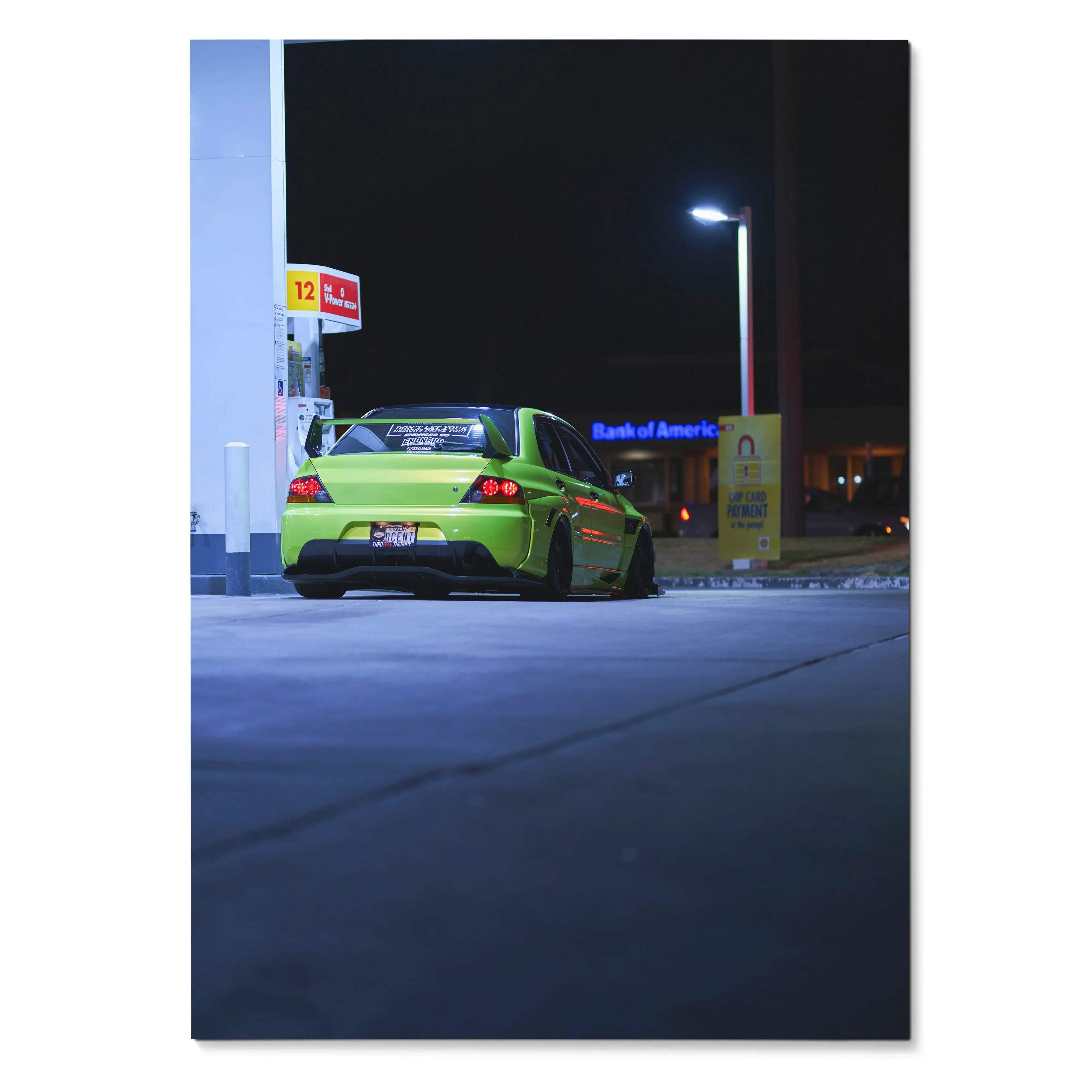 Green Mitsubishi Evo 9 parked at night near gas station, poster wall art in vertical format.