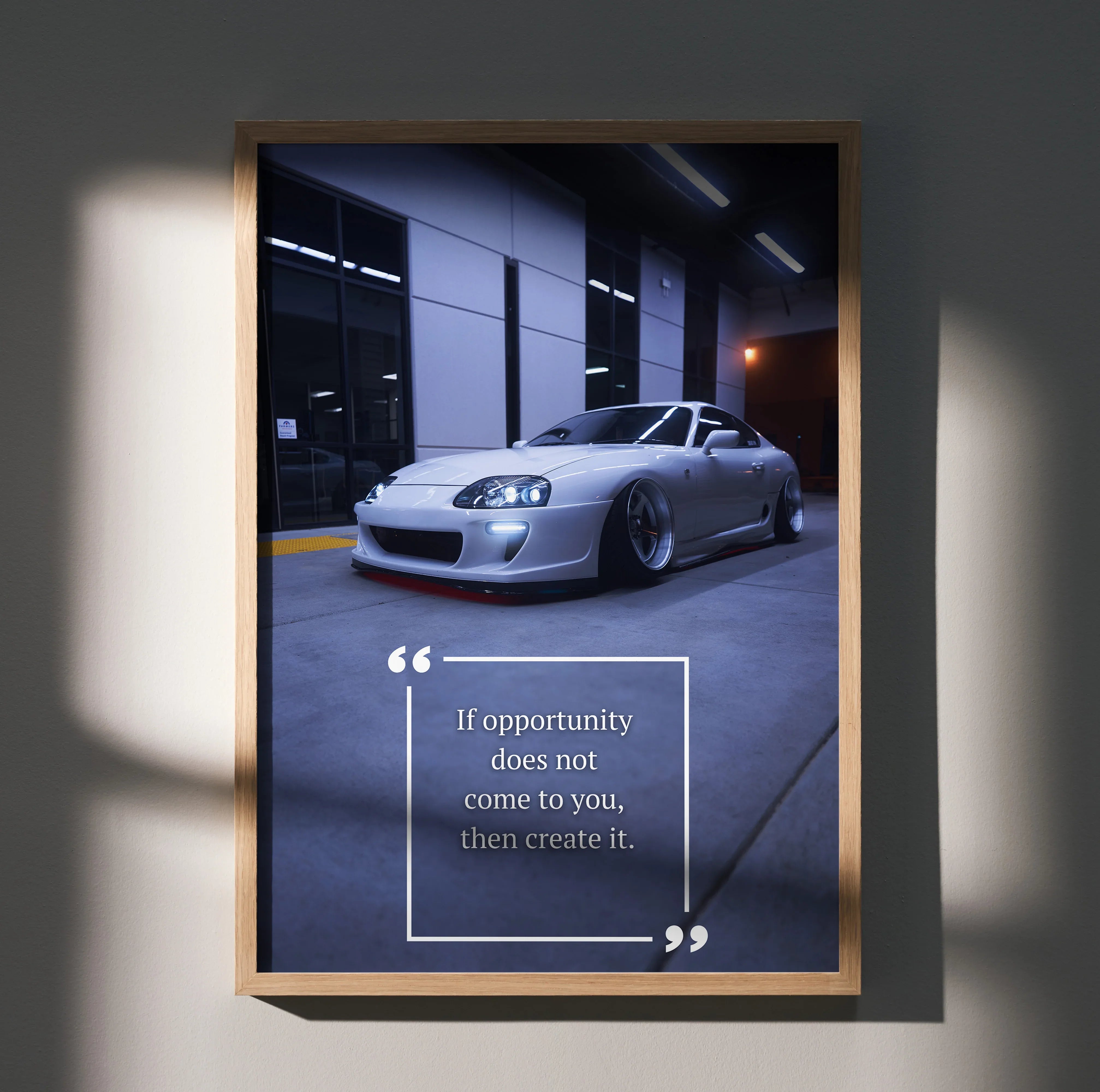 Motivational poster wall art featuring a silver Toyota Supra Mk4 with inspiring quote in a dark garage setting.