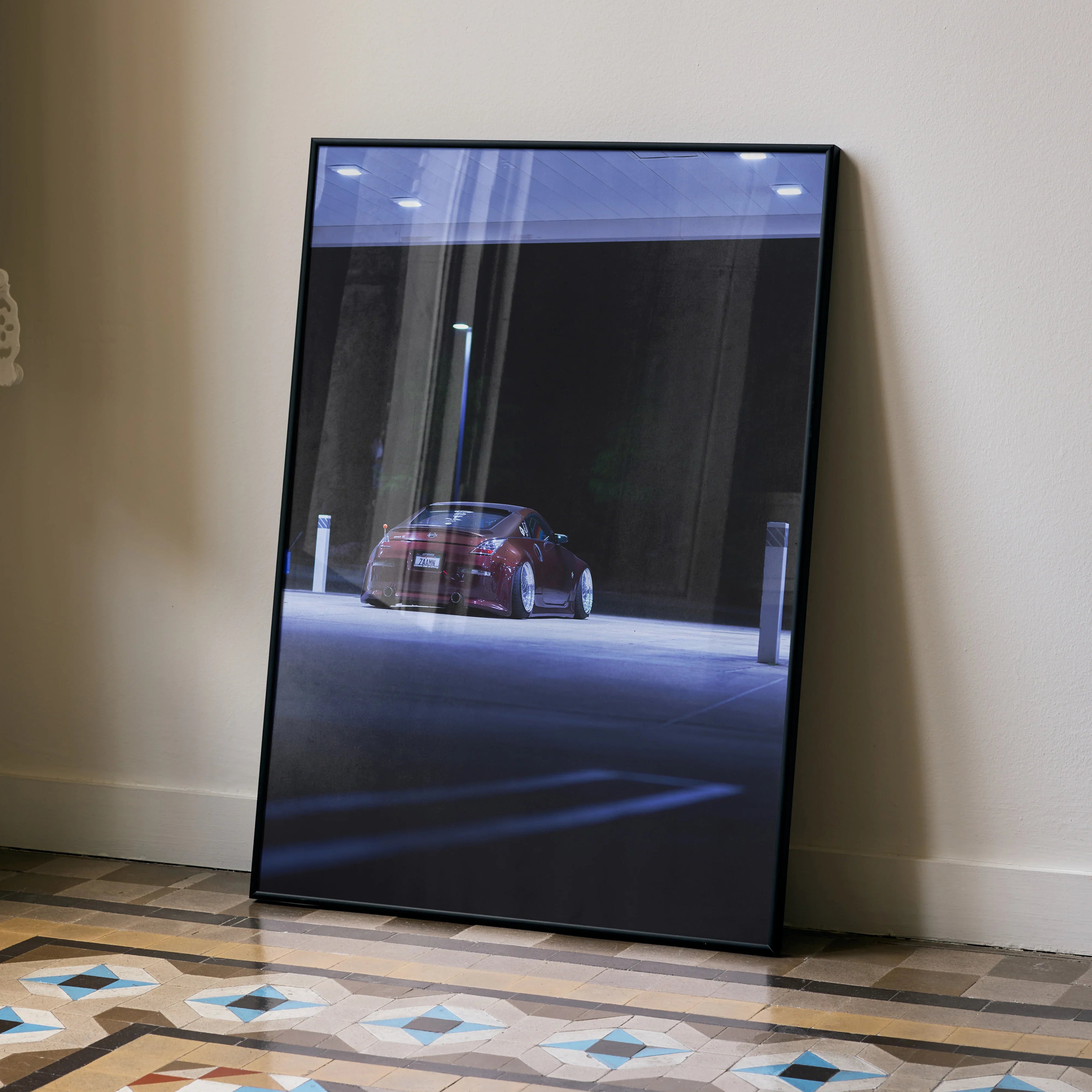Nissan 350Z poster with sleek red car under dim street lighting, modern wall art in black frame.