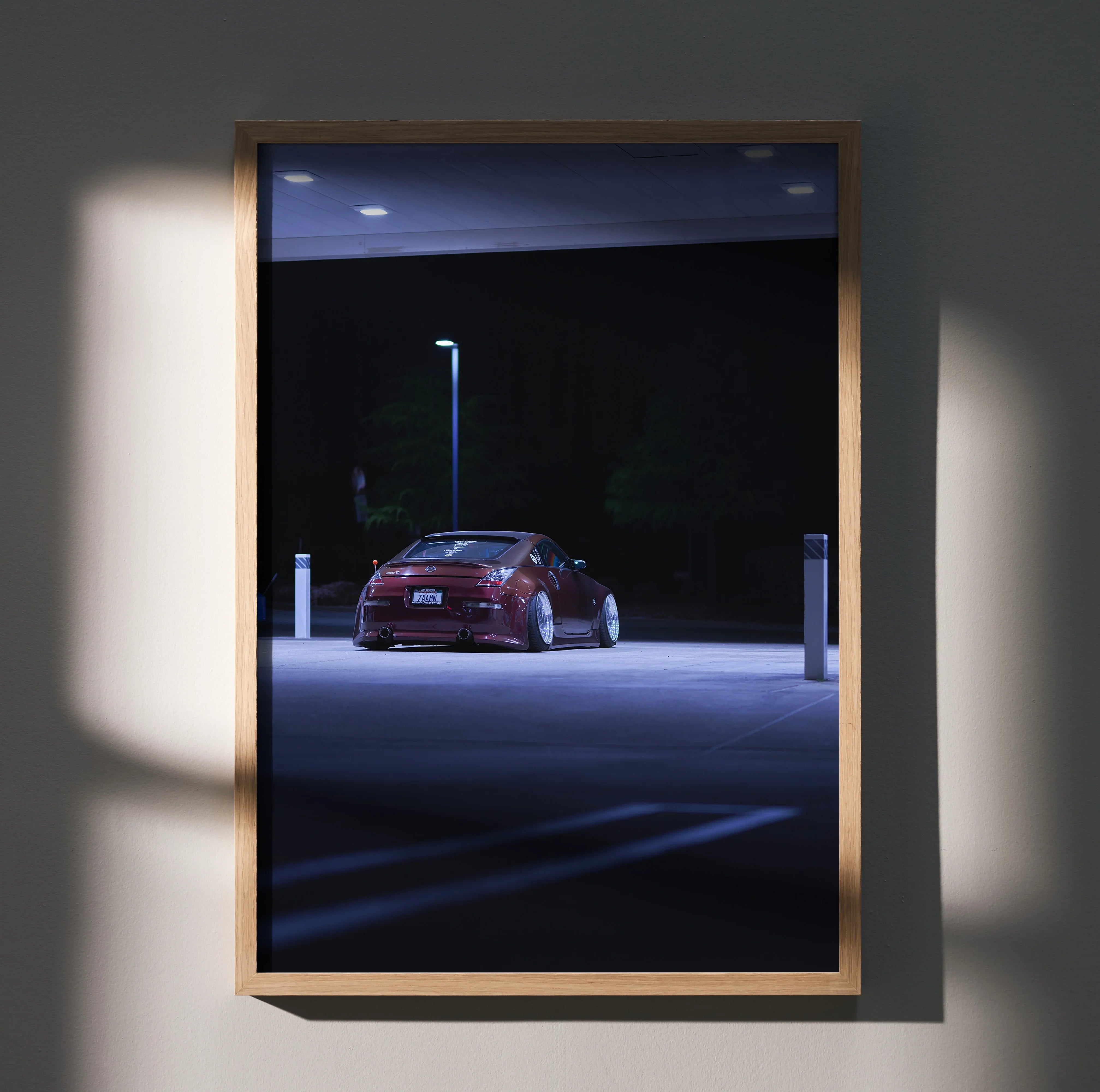 Nissan 350Z red sports car under streetlight at night poster wall art in wooden frame.
