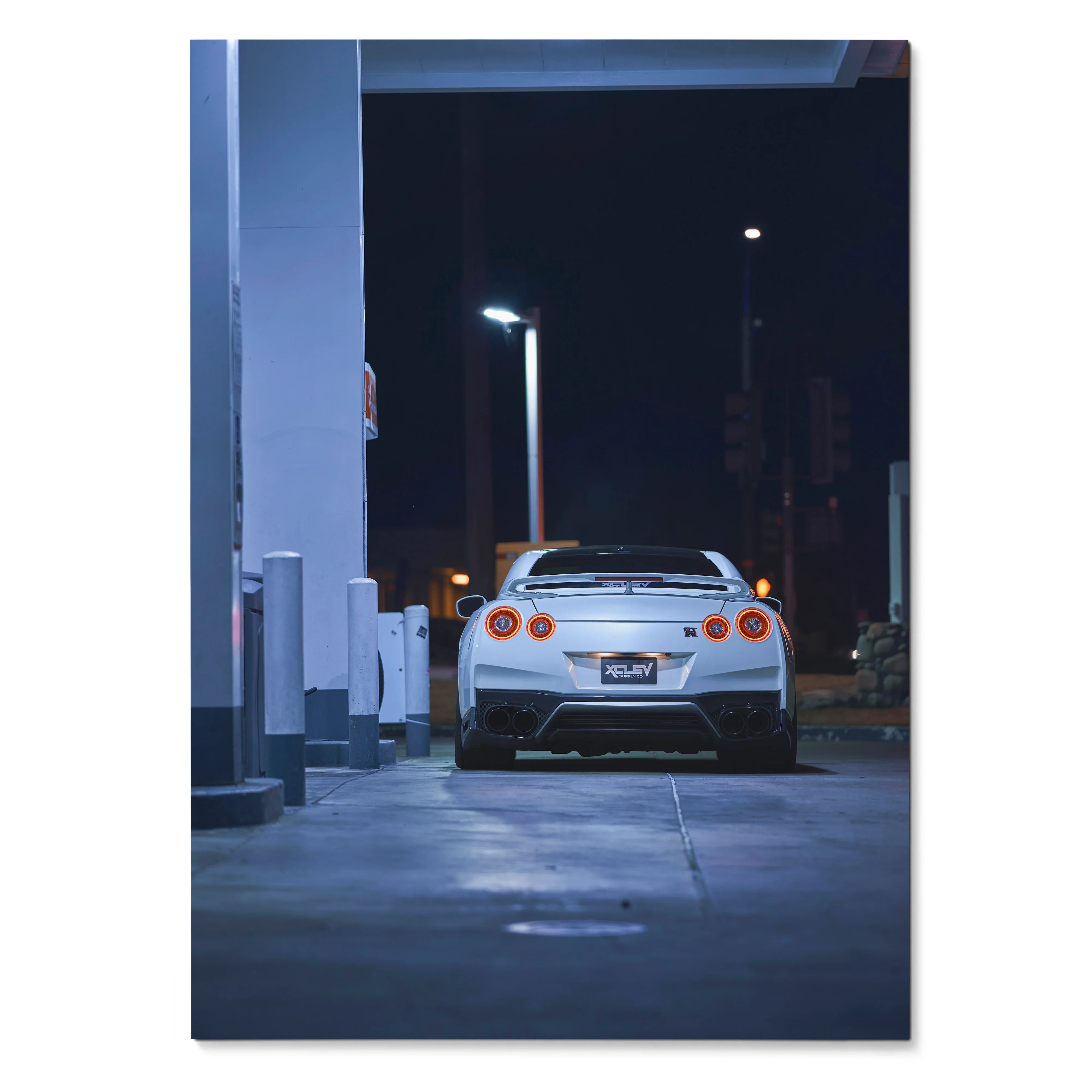 Nissan GTR R35 rear view at night poster wall art with city lights background.