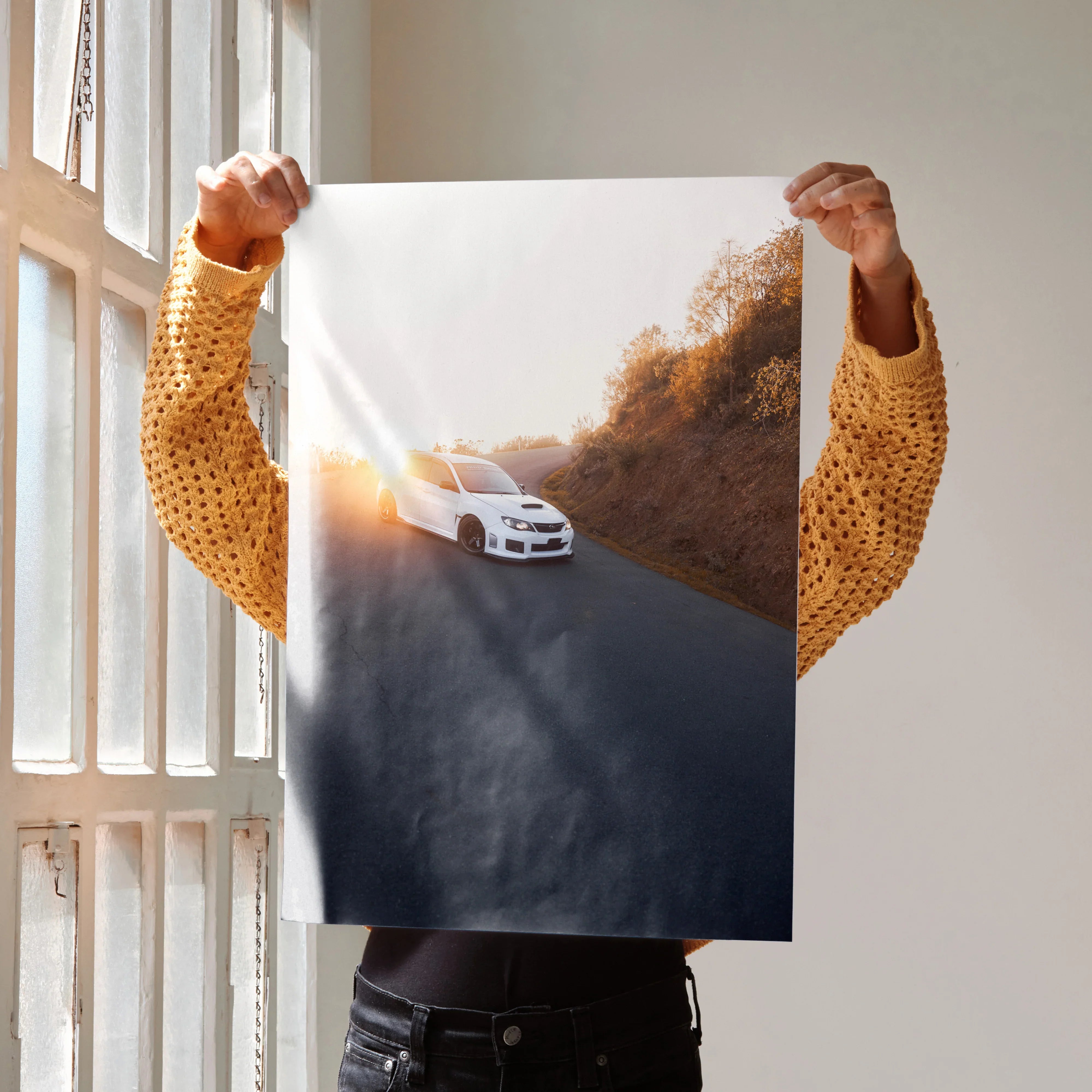 Subaru WRX STI poster wall art showing a white car driving on a hillside road at sunset.