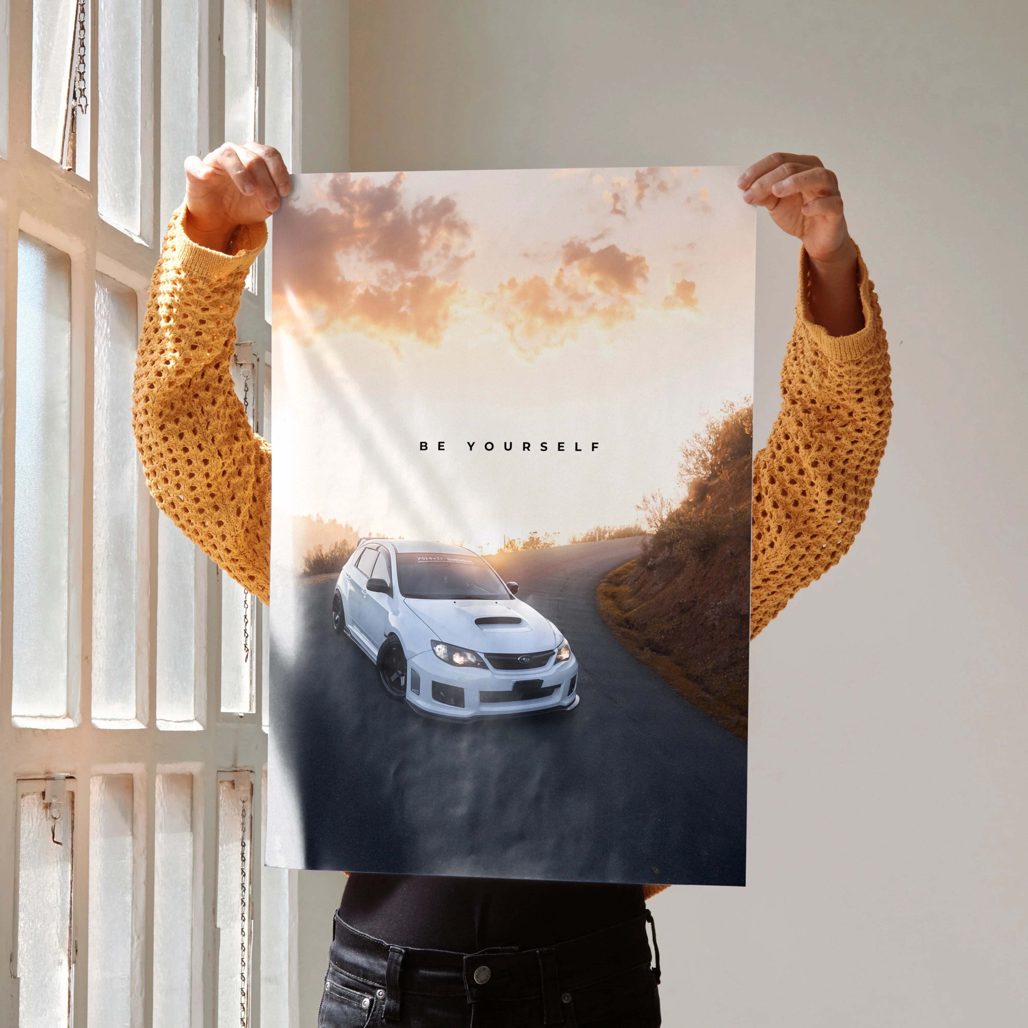Motivational poster wall art featuring a white Subaru WRX STI on a winding road at sunset with the text "Be Yourself".