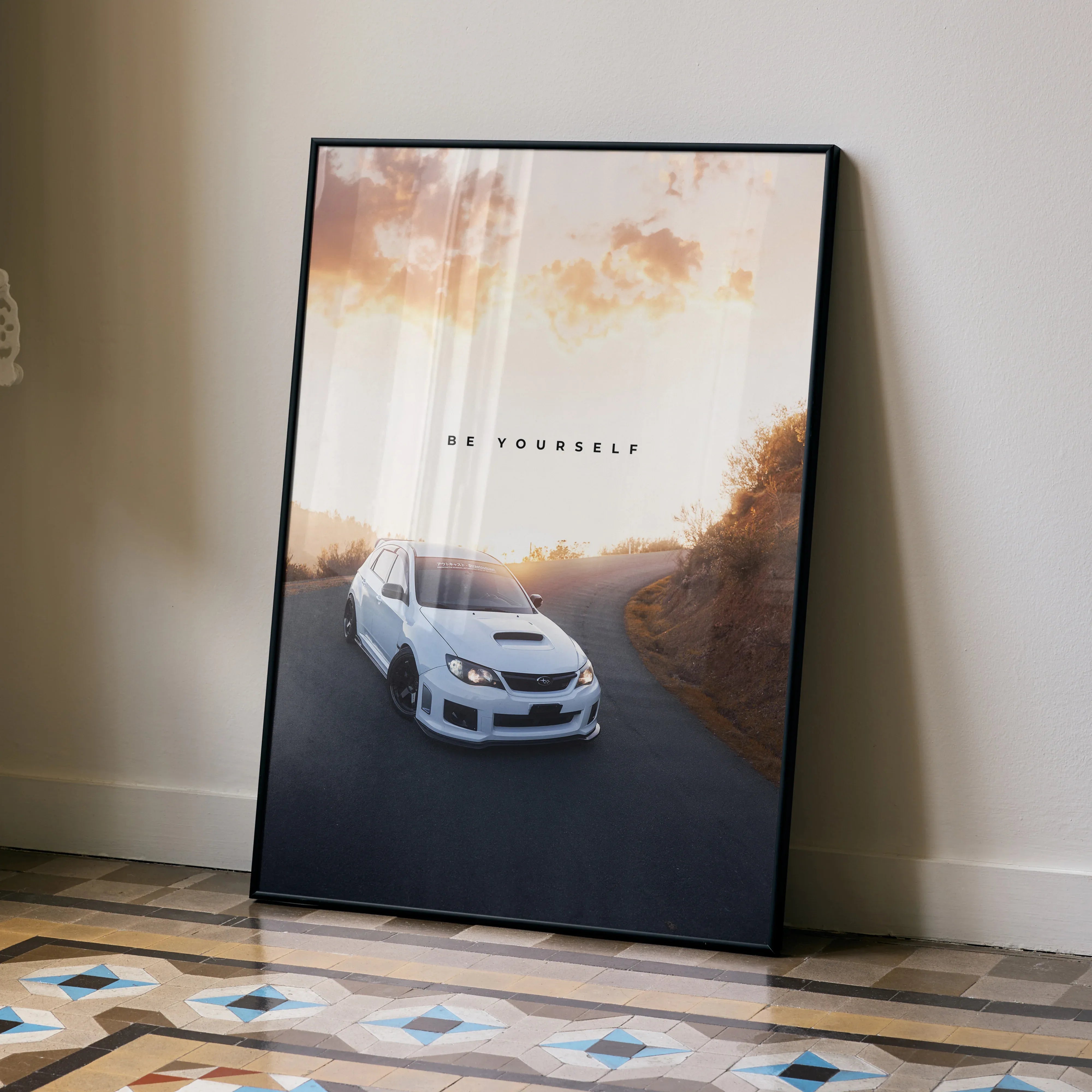 Motivational poster wall art featuring a white Subaru WRX STI on a winding road at sunset.