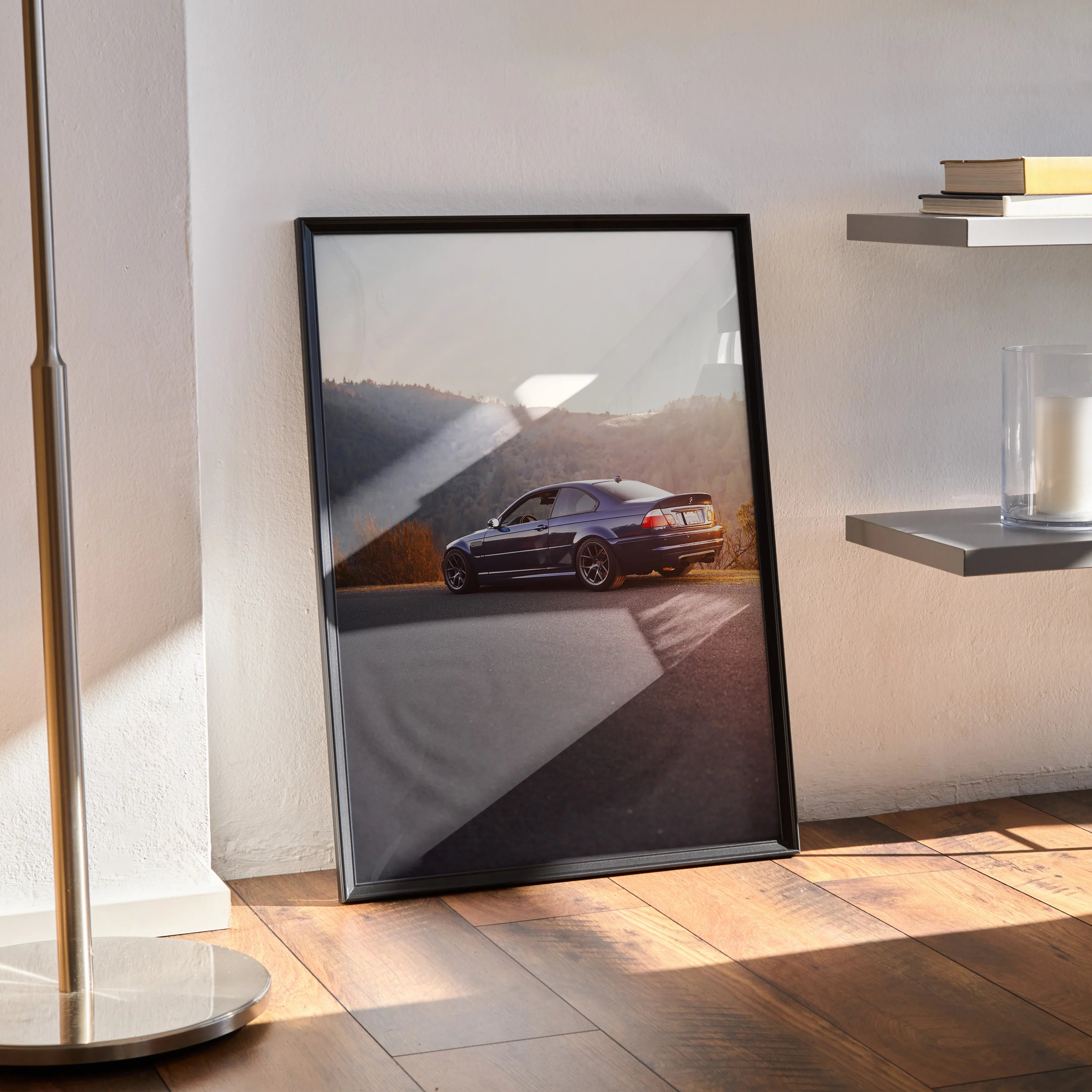 BMW E46 M3 poster wall art featuring the car on a sunlit asphalt road with scenic hills background.