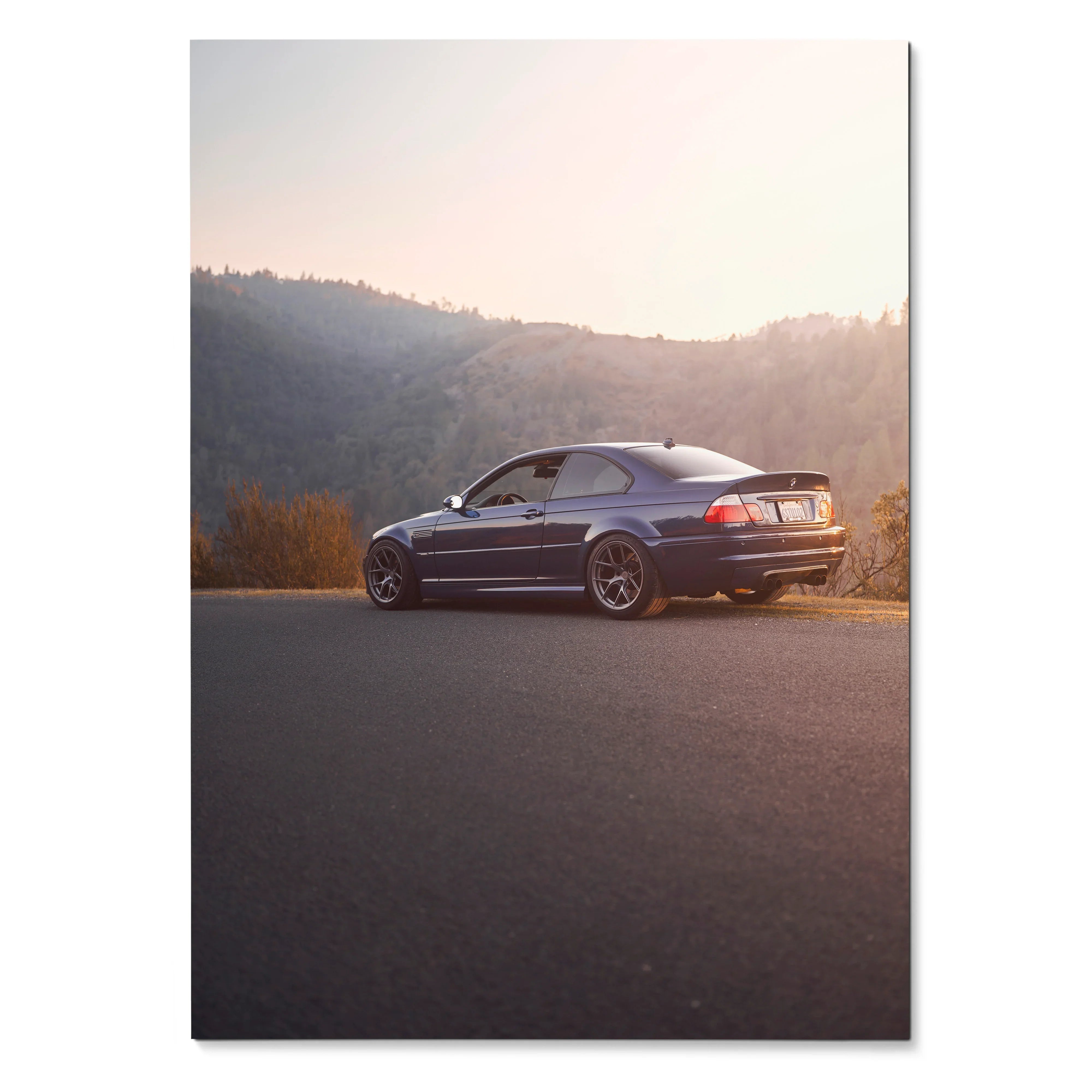 BMW E46 M3 in sunset light on mountain road poster wall art with sleek sporty design.