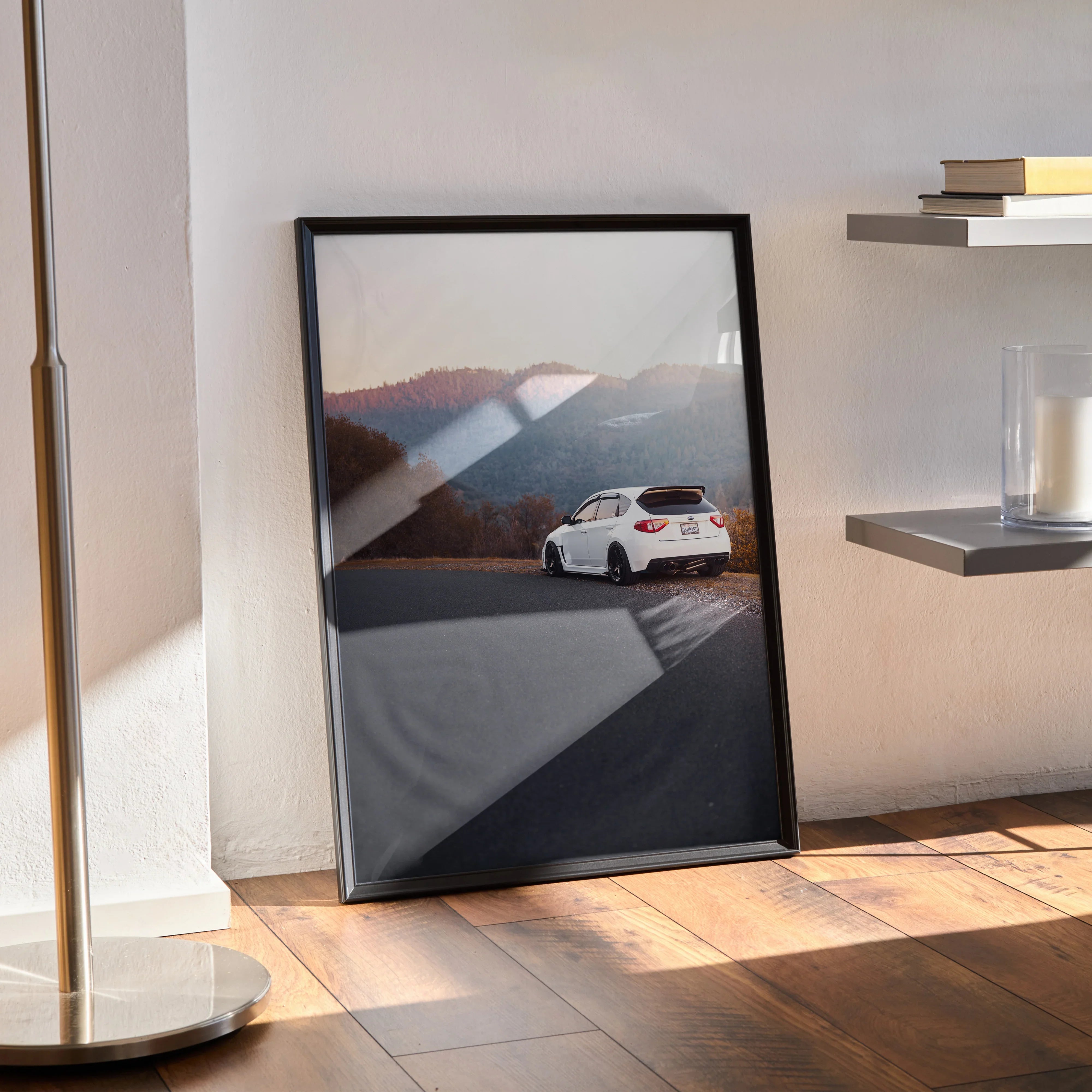 Framed Subaru WRX STI poster with white car on mountain road, automotive wall art in modern room.