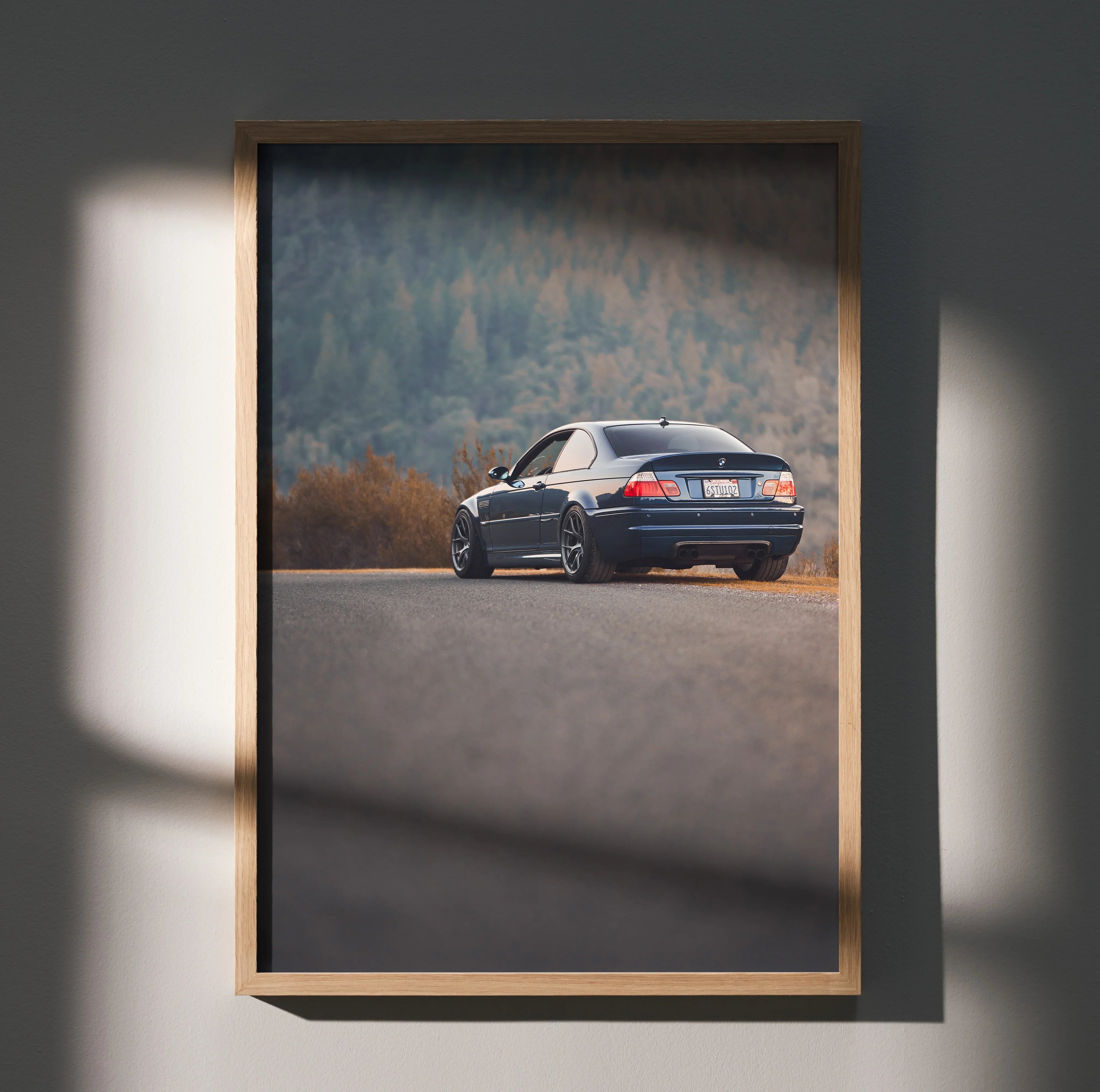 BMW E46 M3 black car on road with forest background poster wall art in wooden frame.