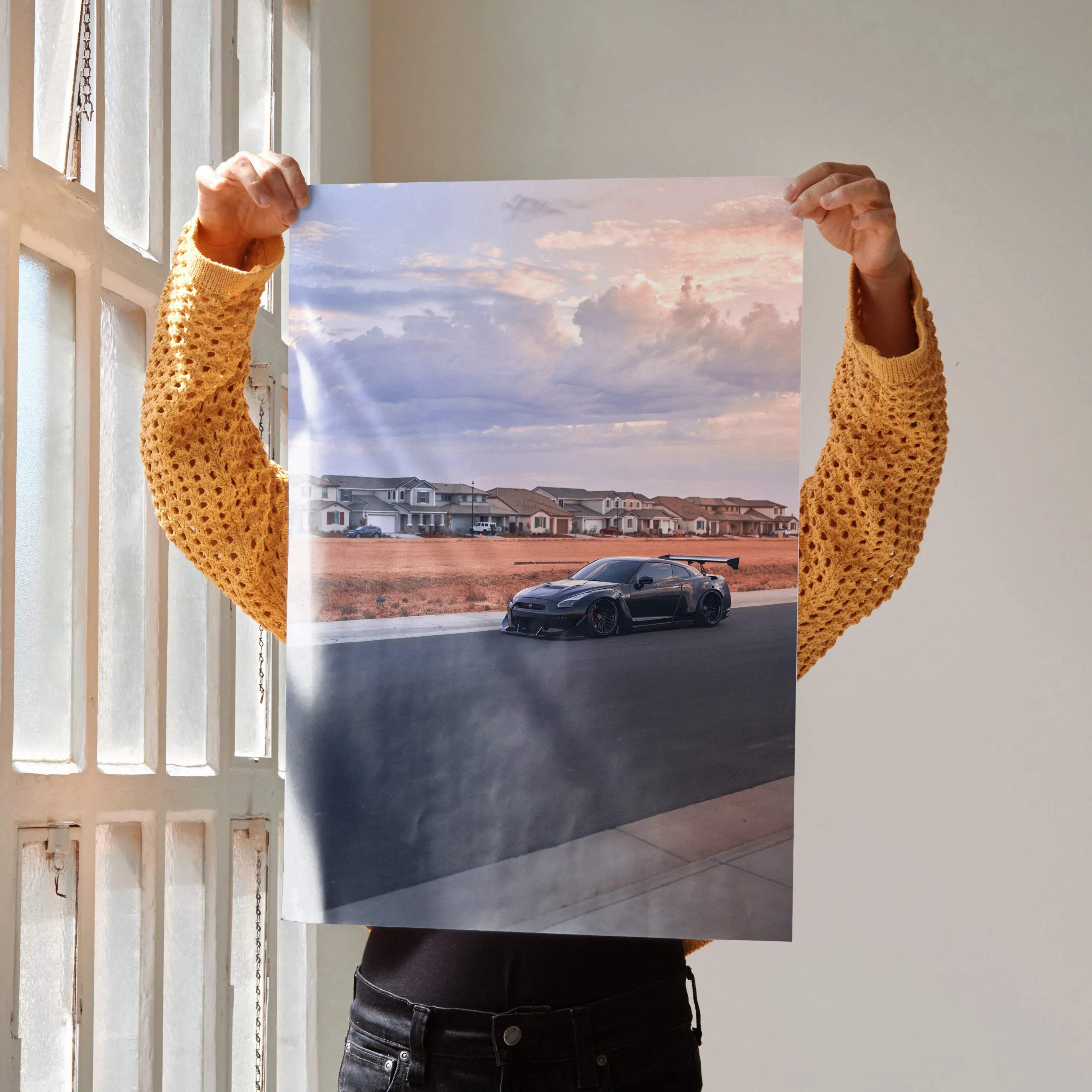 Black nissan r35 gtr widebody sports car with rear wing in motion on asphalt road dramatic sky art print