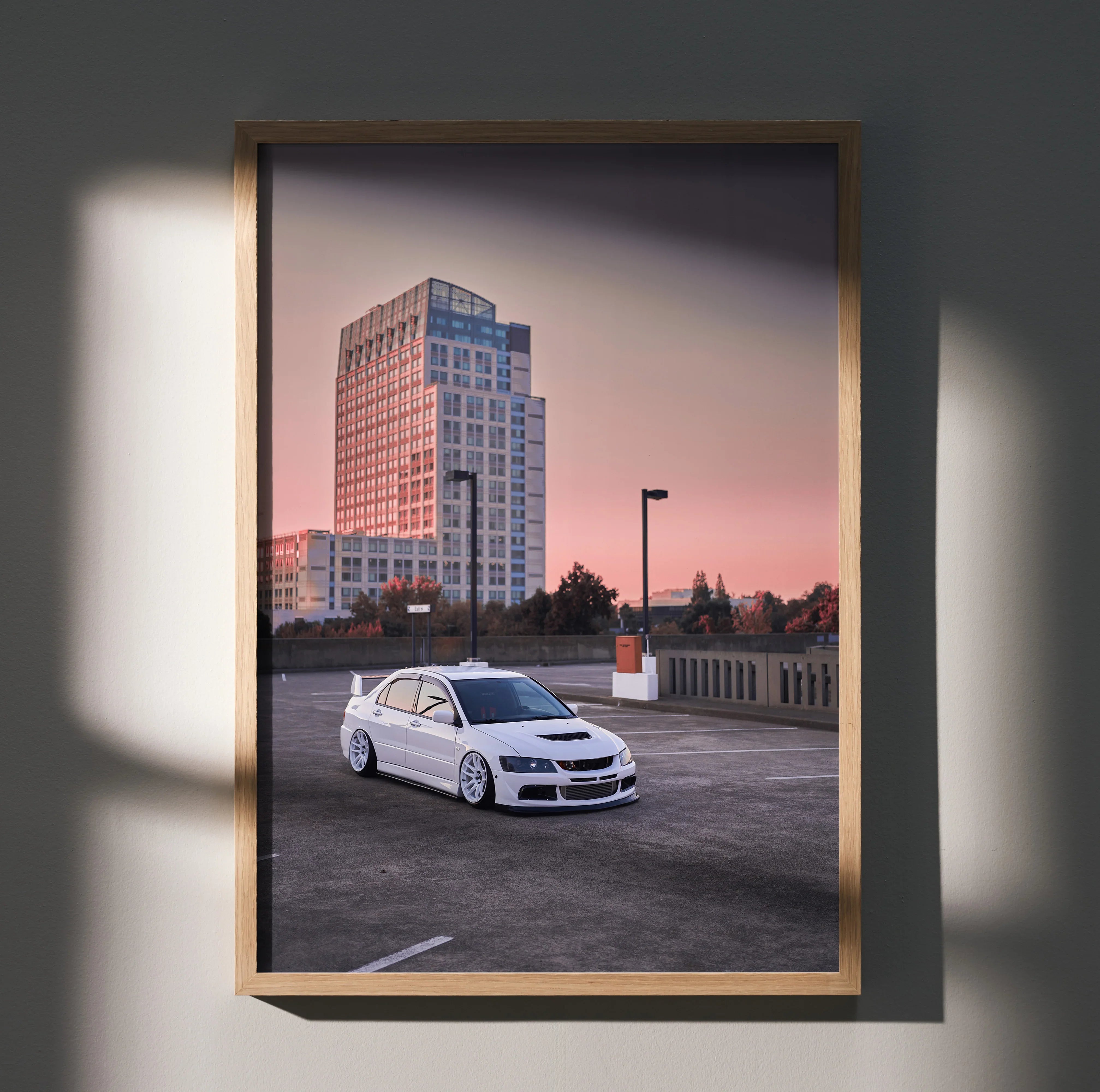Mitsubishi Evo 8 poster with white car in urban parking lot at sunset, framed wall art.