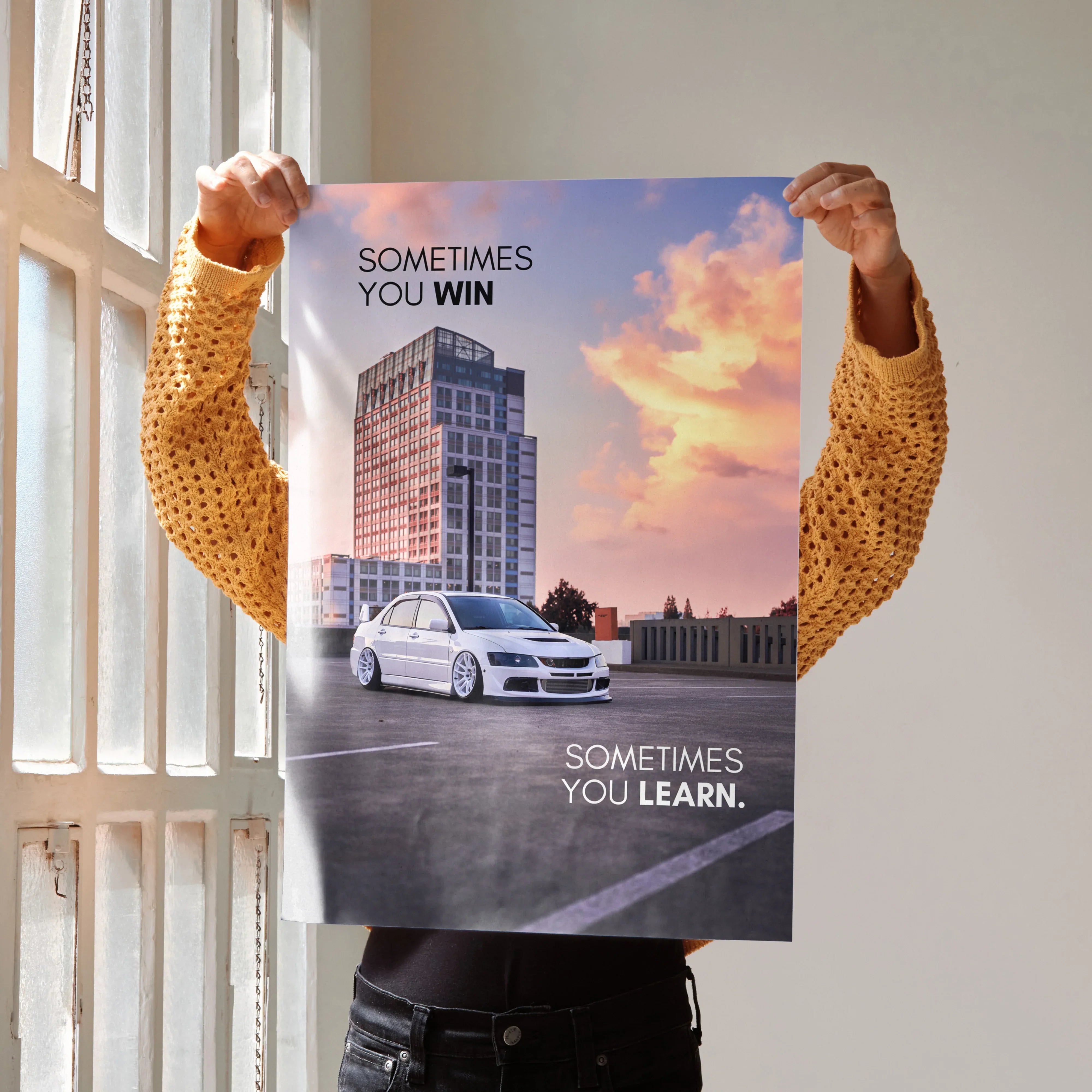 Motivational poster wall art featuring white Mitsubishi Evo 8 in cityscape at sunset with inspiring text.