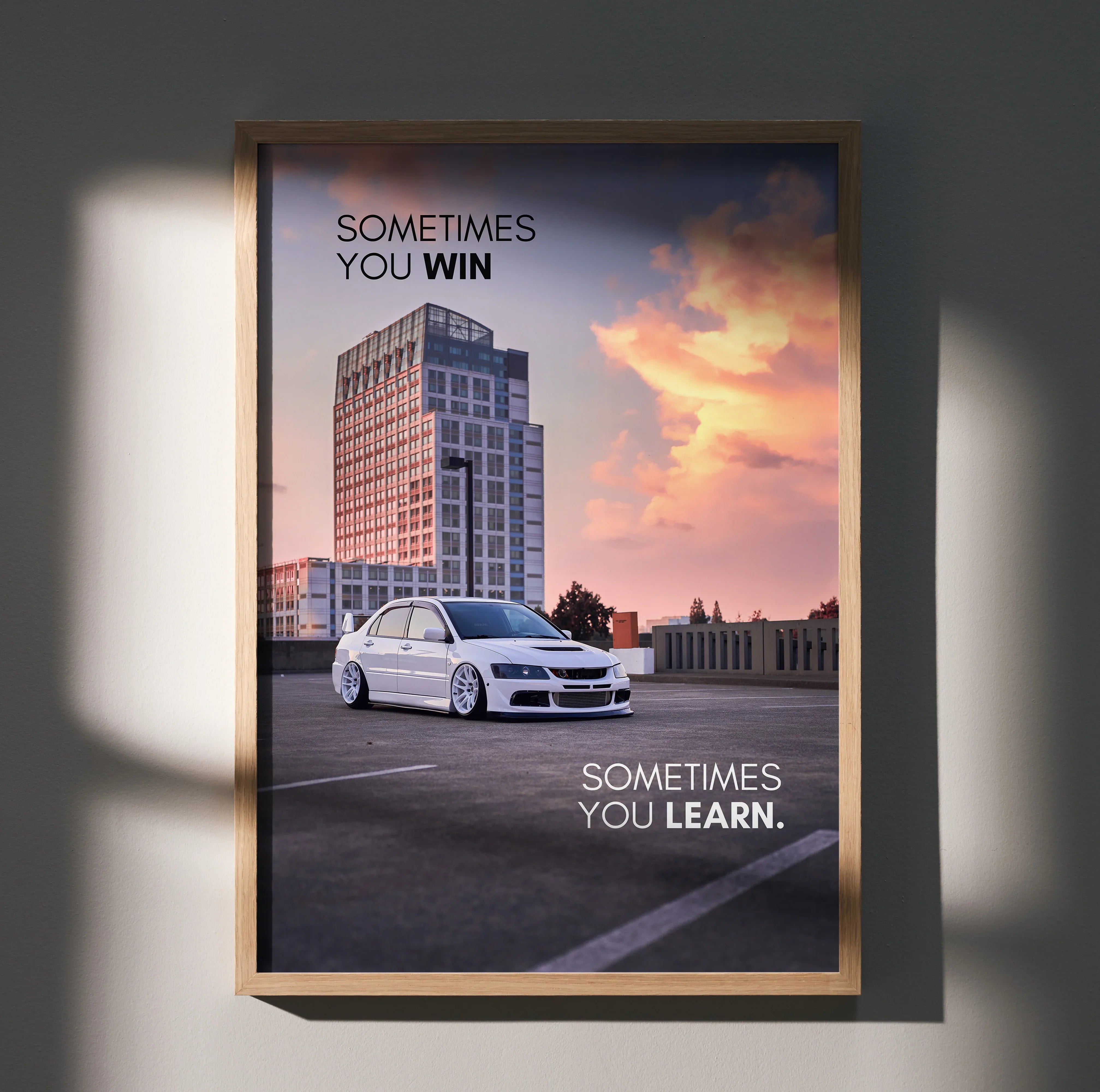 Motivational poster wall art featuring white Mitsubishi Evo 8 with sunset cityscape and inspiring text.