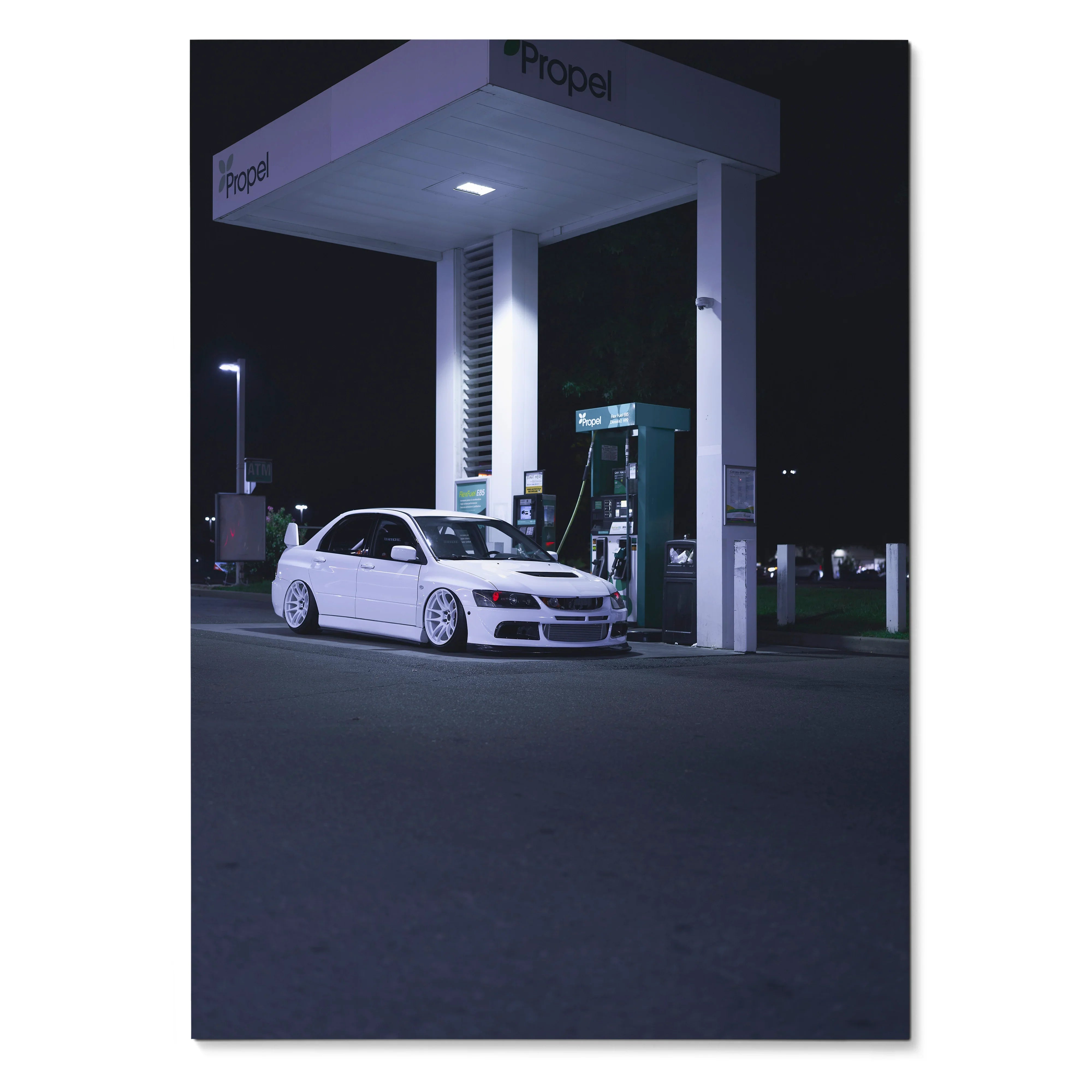 White Mitsubishi Evo 8 parked at nighttime gas station under bright lights poster wall art.
