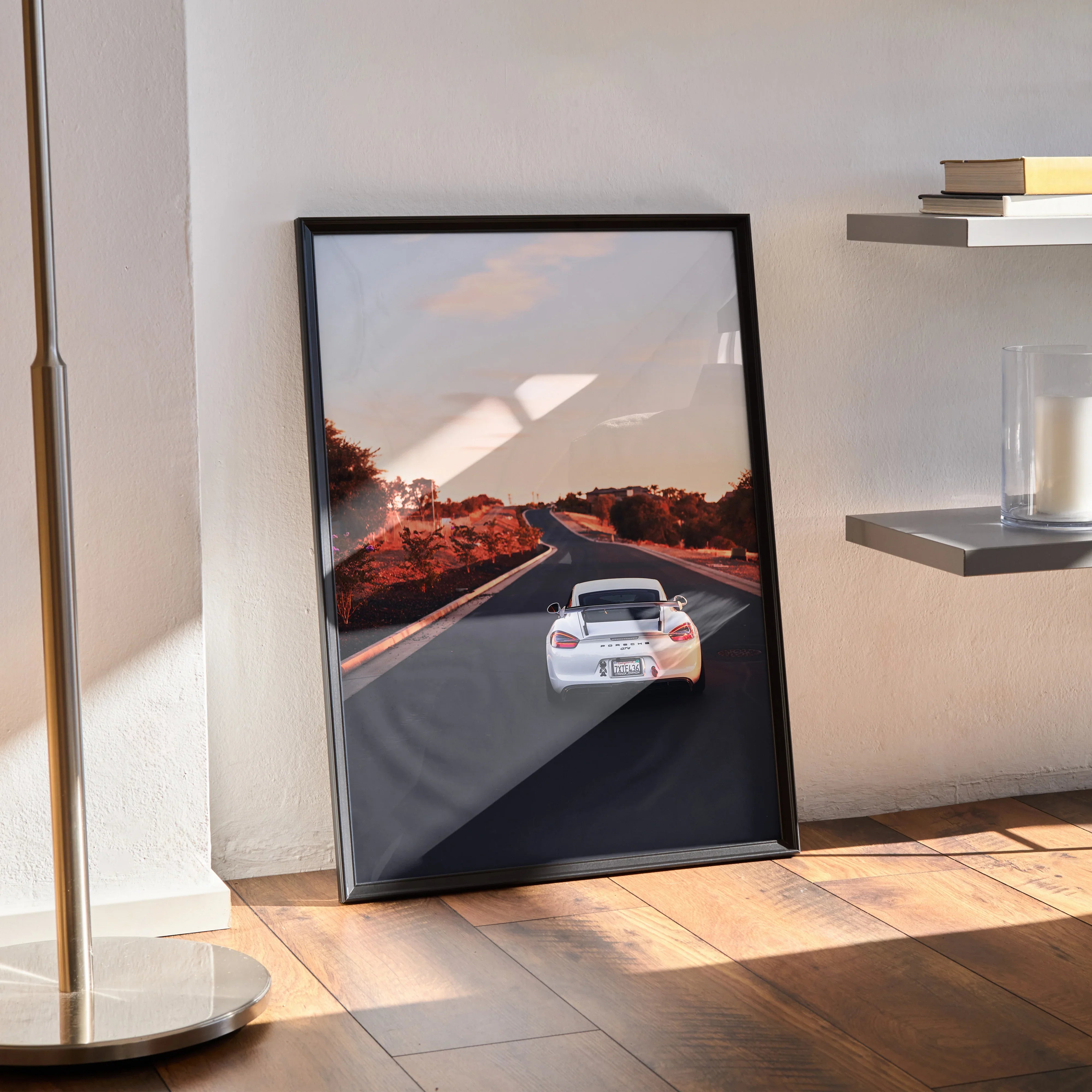 Porsche Cayman GT4 poster showing rear view on scenic highway, modern black frame wall art.