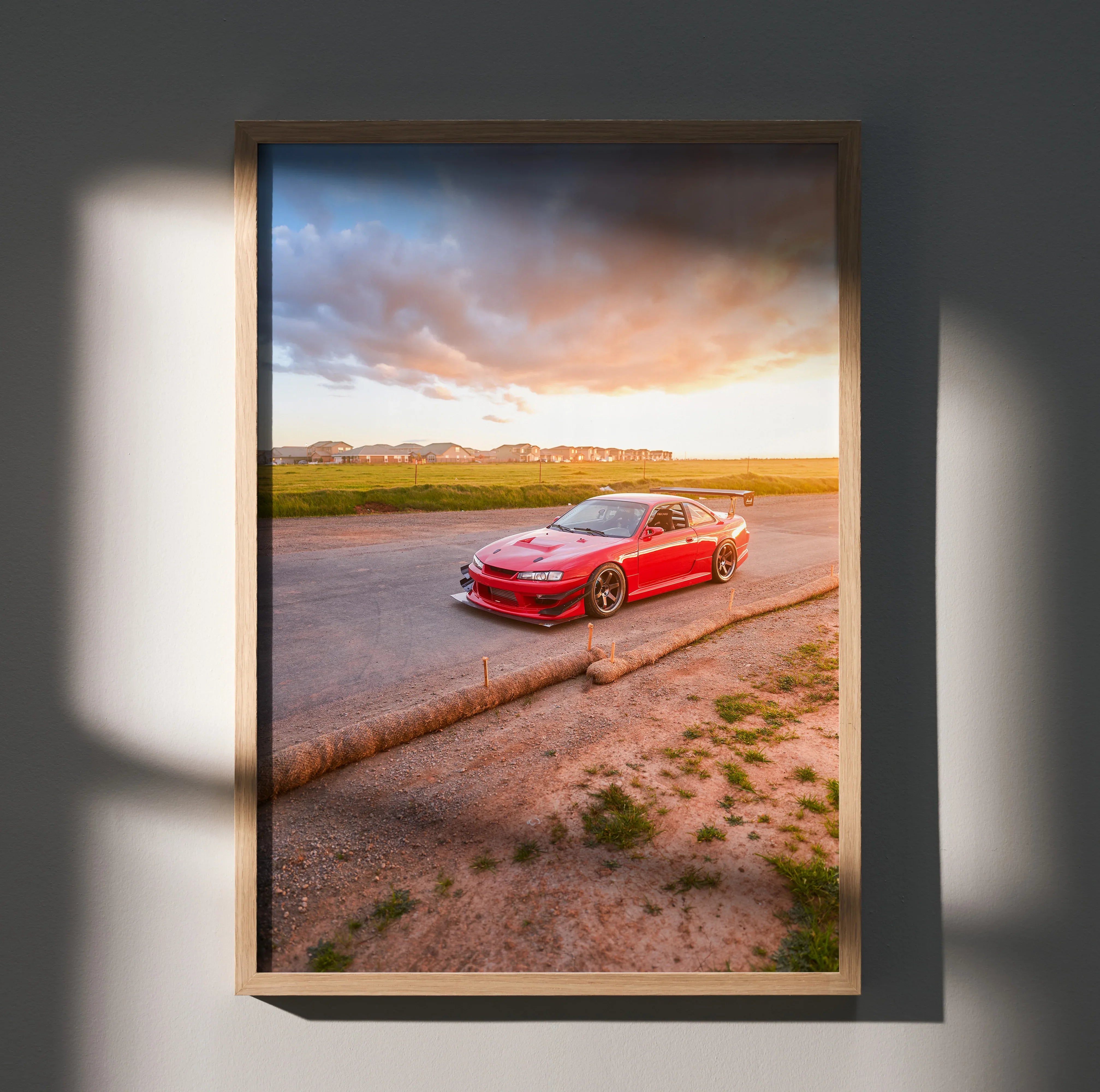 Nissan 240sx S14 Kouki red car at sunset poster wall art in wooden frame on textured wall.