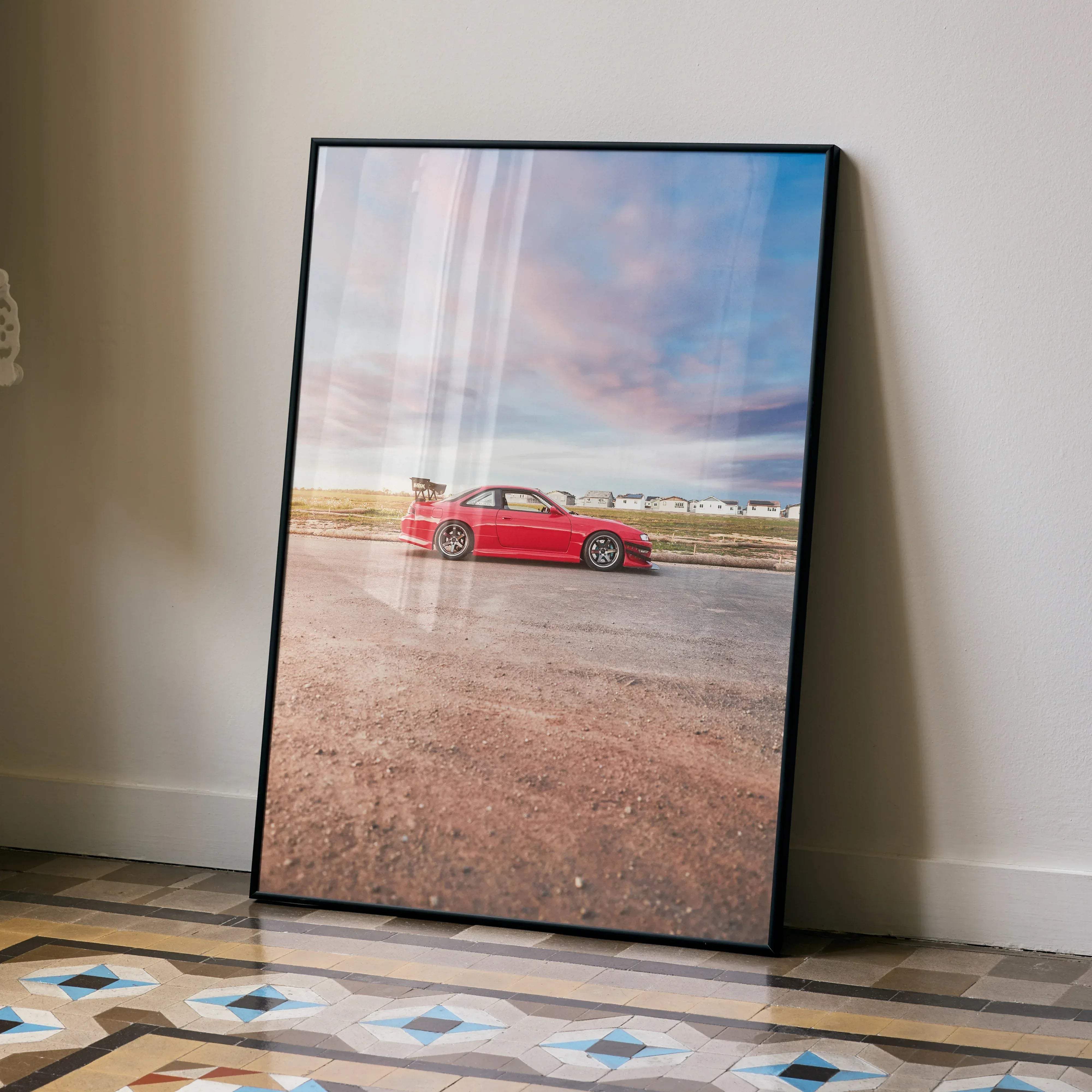 Black-framed print of a vibrant red nissan 240sx s14 kouki sports car under a soft pastel sky high resolution poster