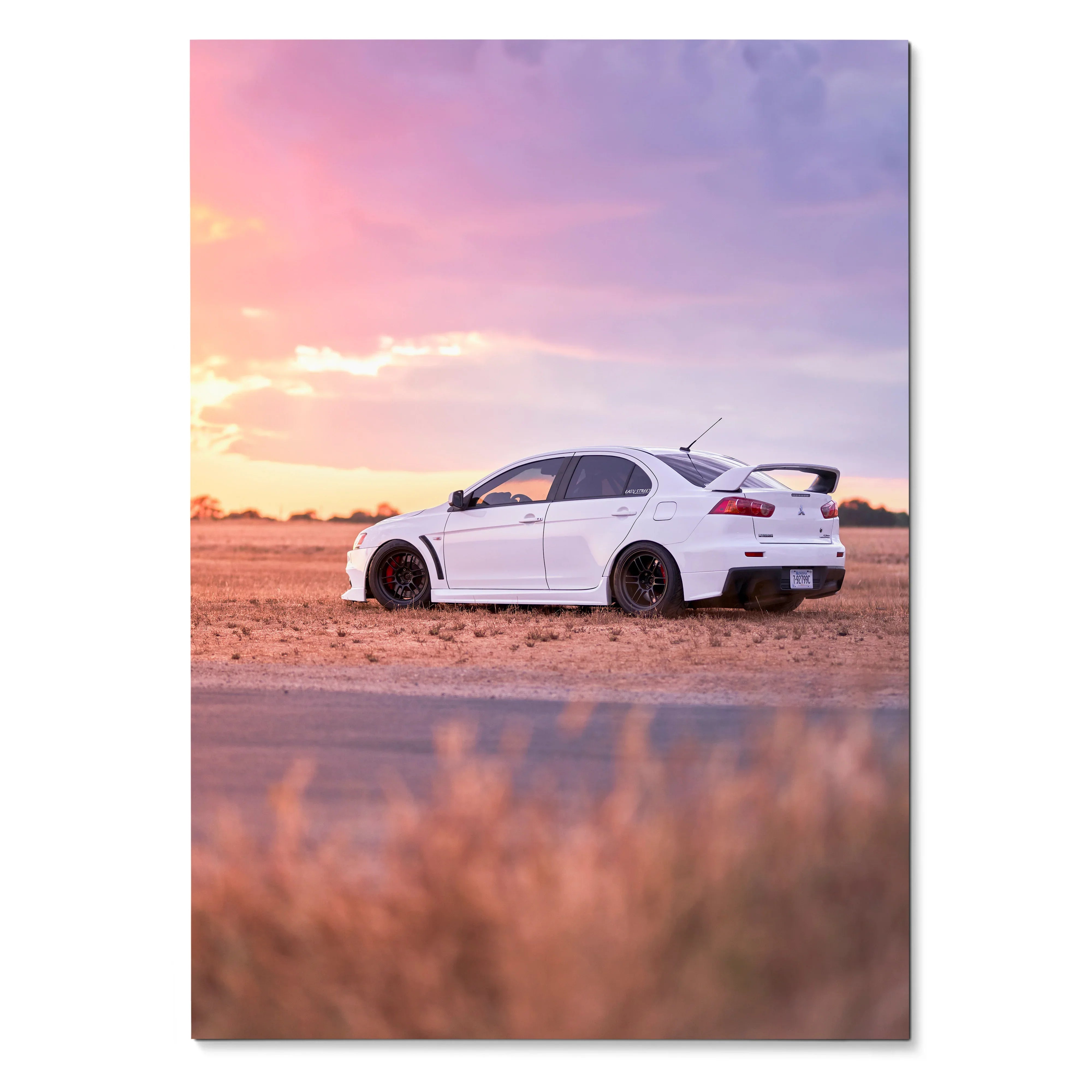 Mitsubishi Evo 10 parked on dirt at sunset with pink and purple sky poster wall art.