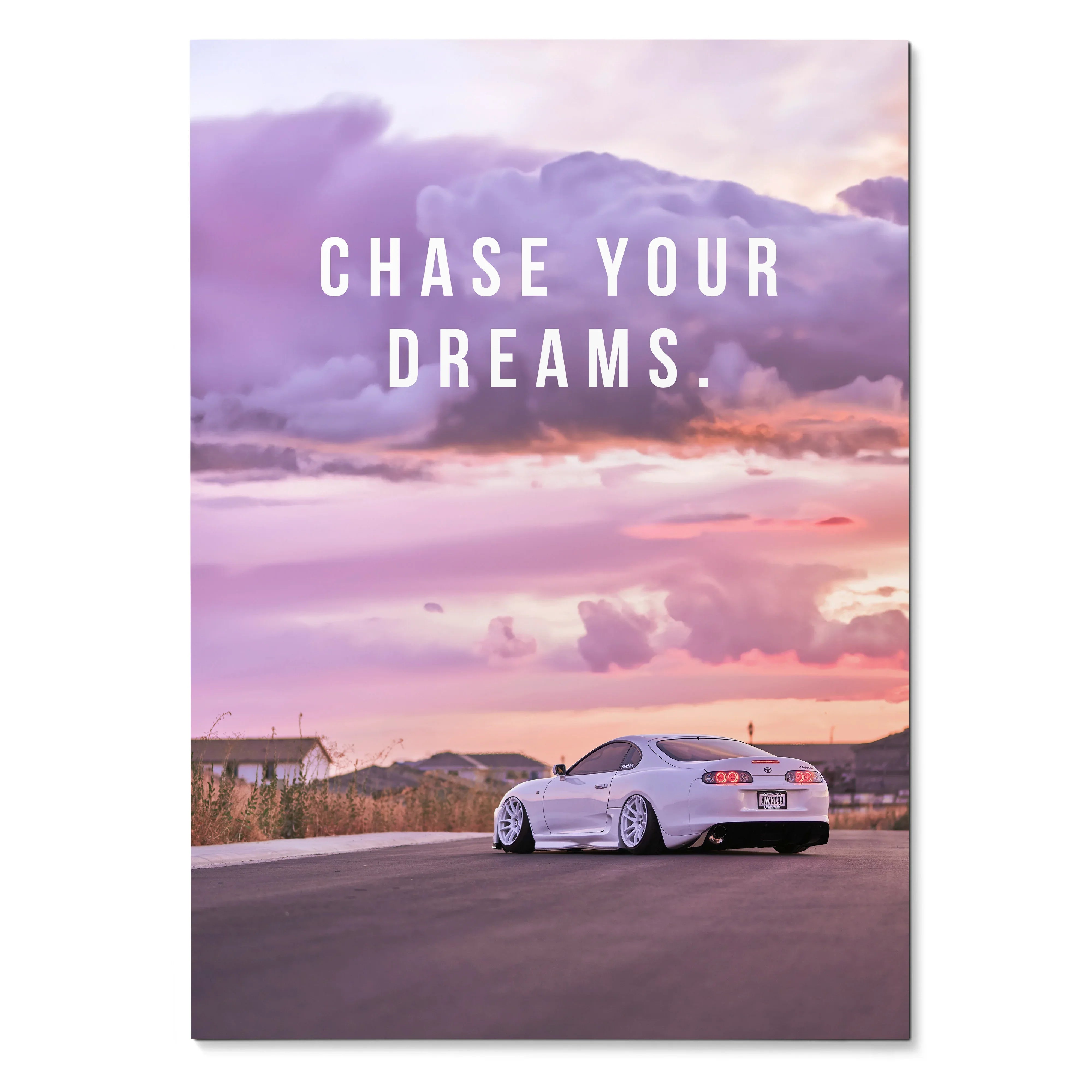 Poster wall art featuring a white Toyota Supra Mk4 under a purple and pink sunset sky with "Chase Your Dreams" text.