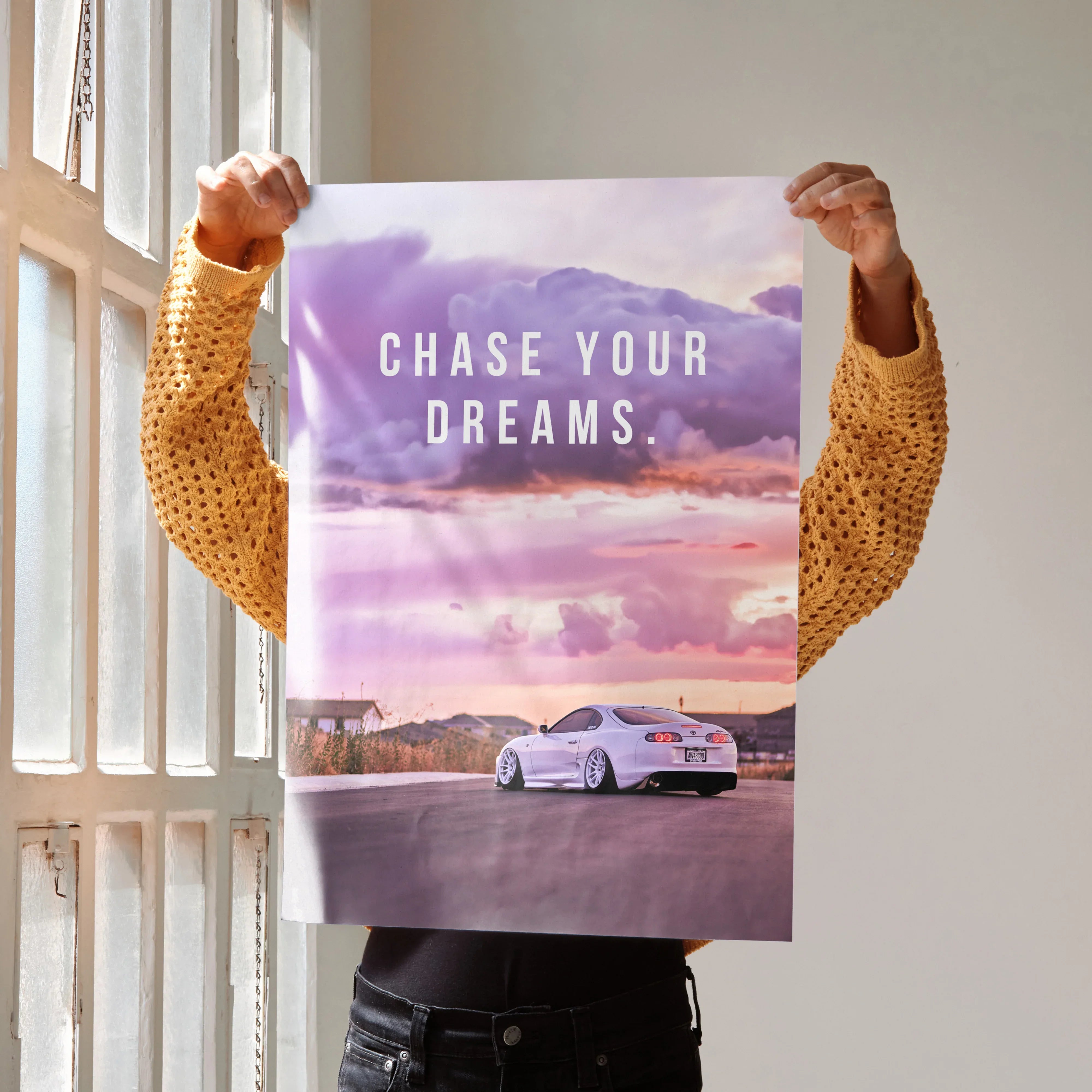 Motivational poster wall art with Toyota Supra Mk4 against a purple and pink sunset sky, "Chase Your Dreams" text.