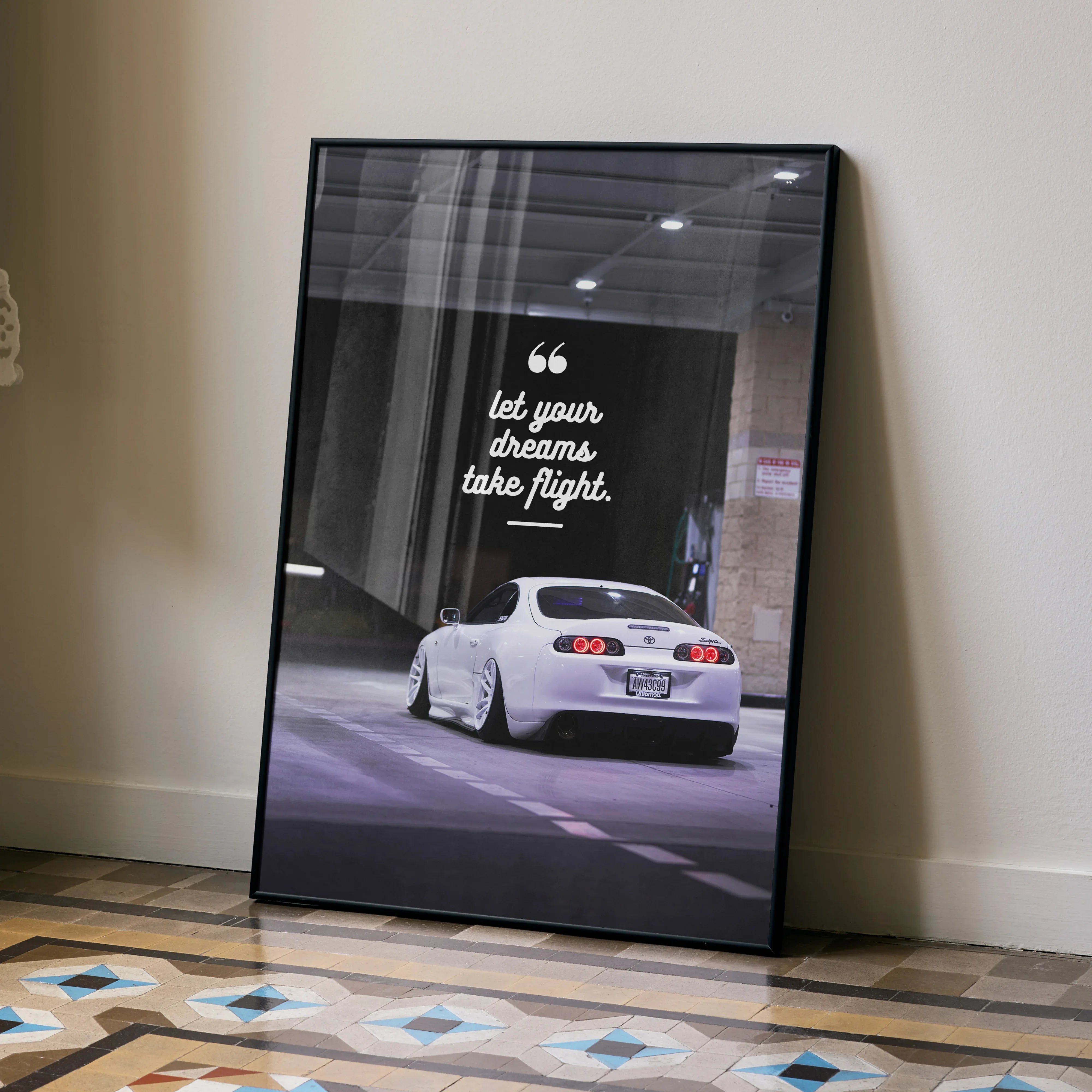 Motivational poster wall art featuring white Toyota Supra Mk4 with inspiring text "Let your dreams take flight".