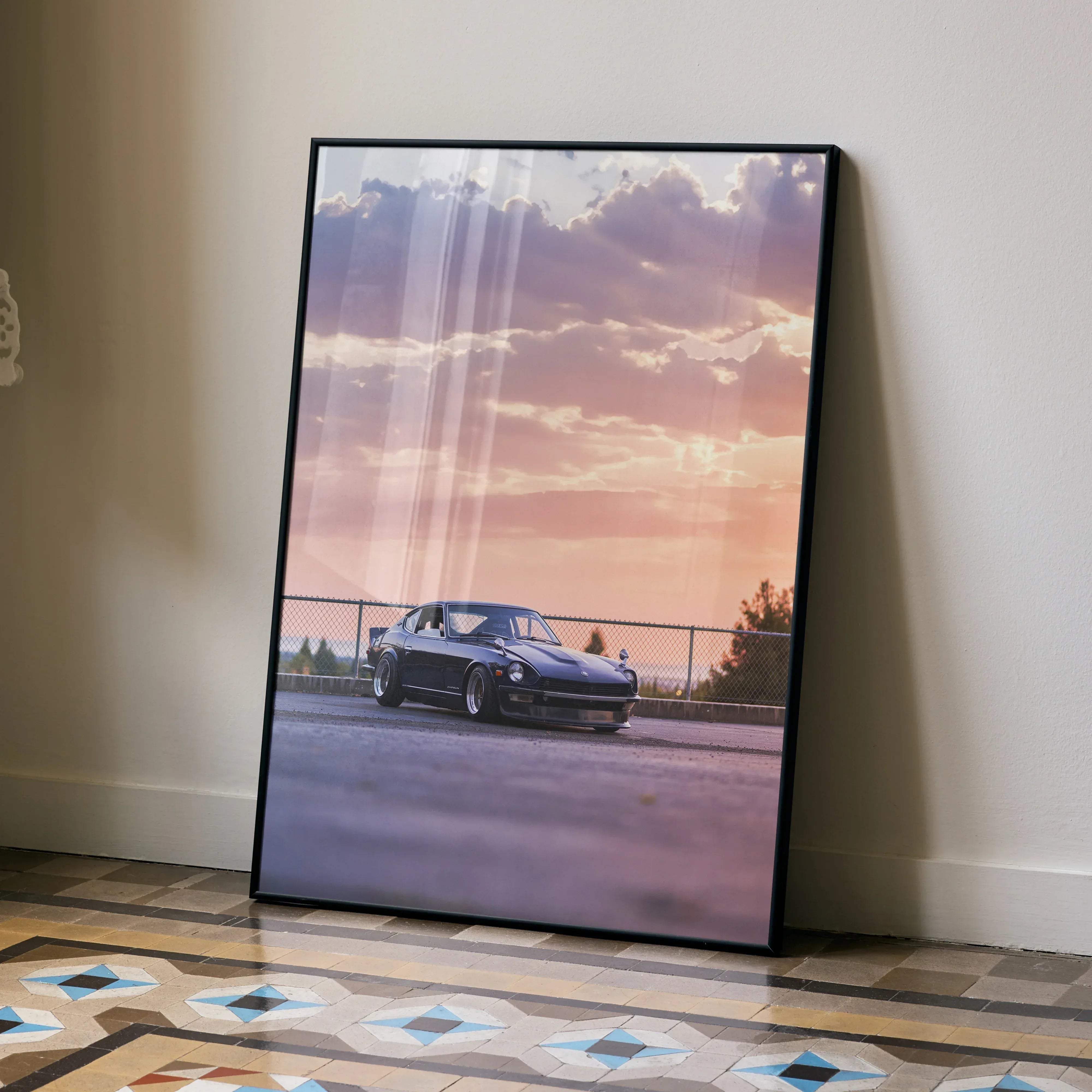 Black-framed canvas print of a dark blue Nissan 240Z sports car under a soft pink and purple sunset sky