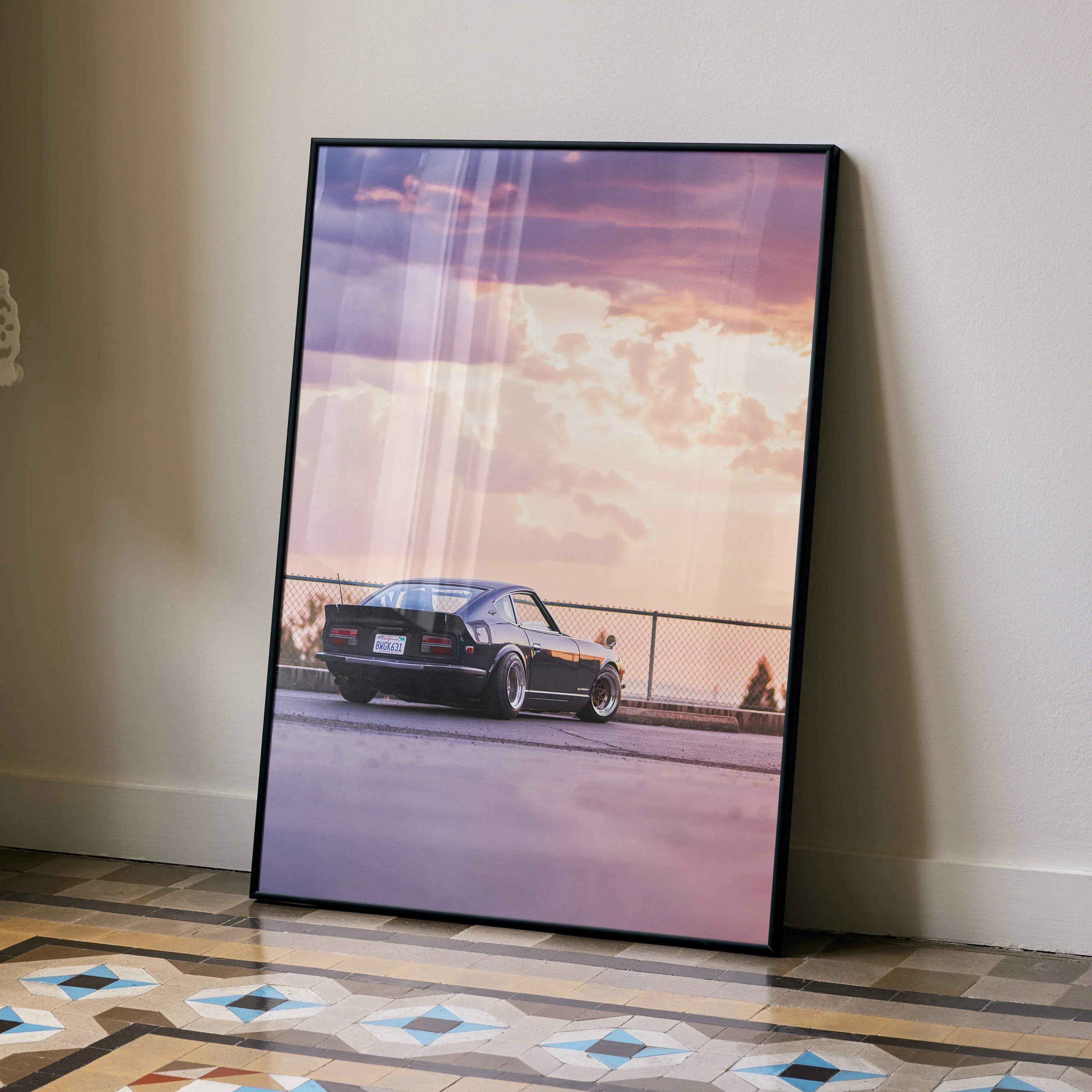 Black framed poster of a vintage Nissan 240z sports car under a pink and purple sunset sky in high resolution