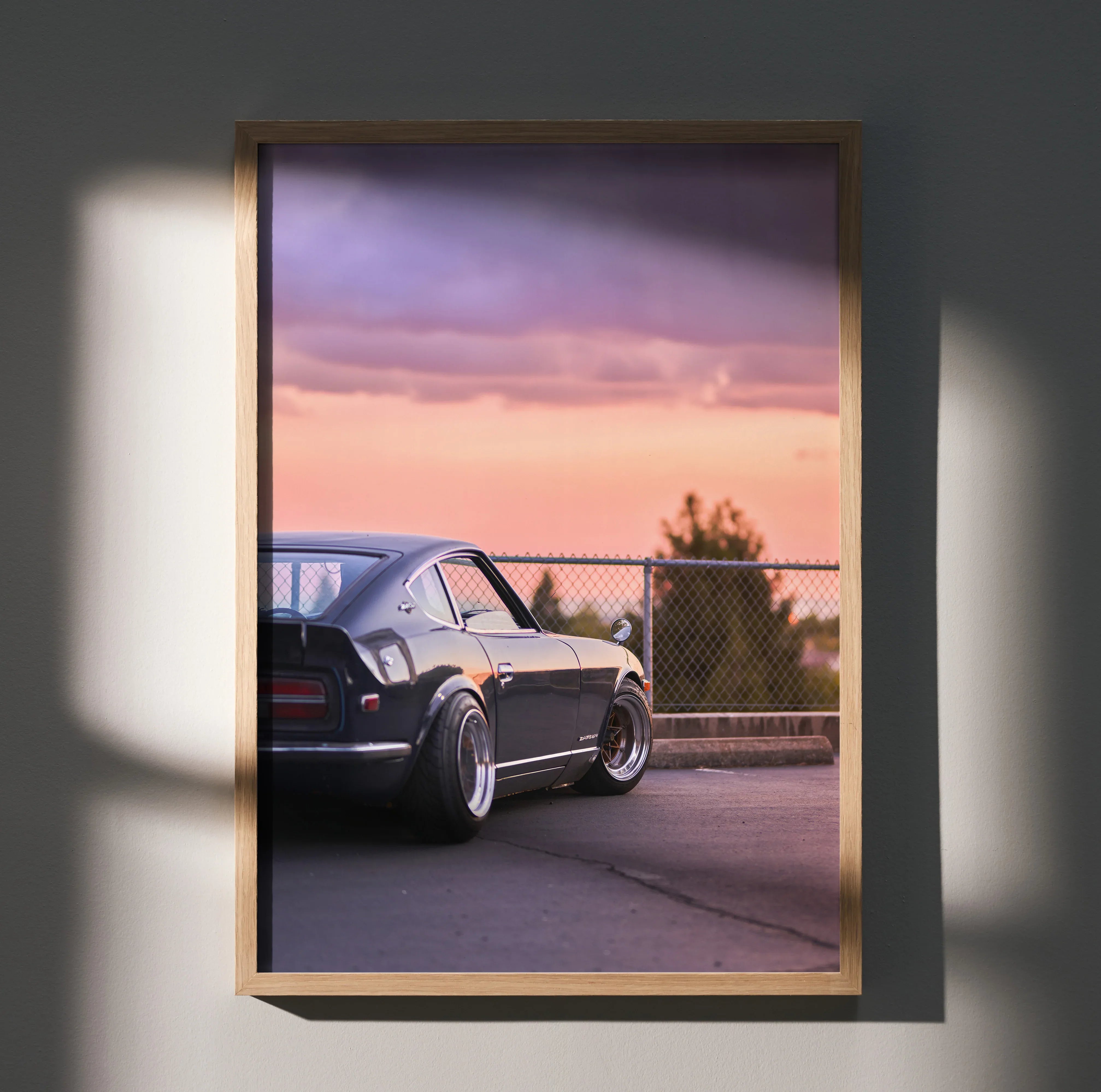Nissan 240z parked at sunset with purple sky poster wall art in wooden frame.