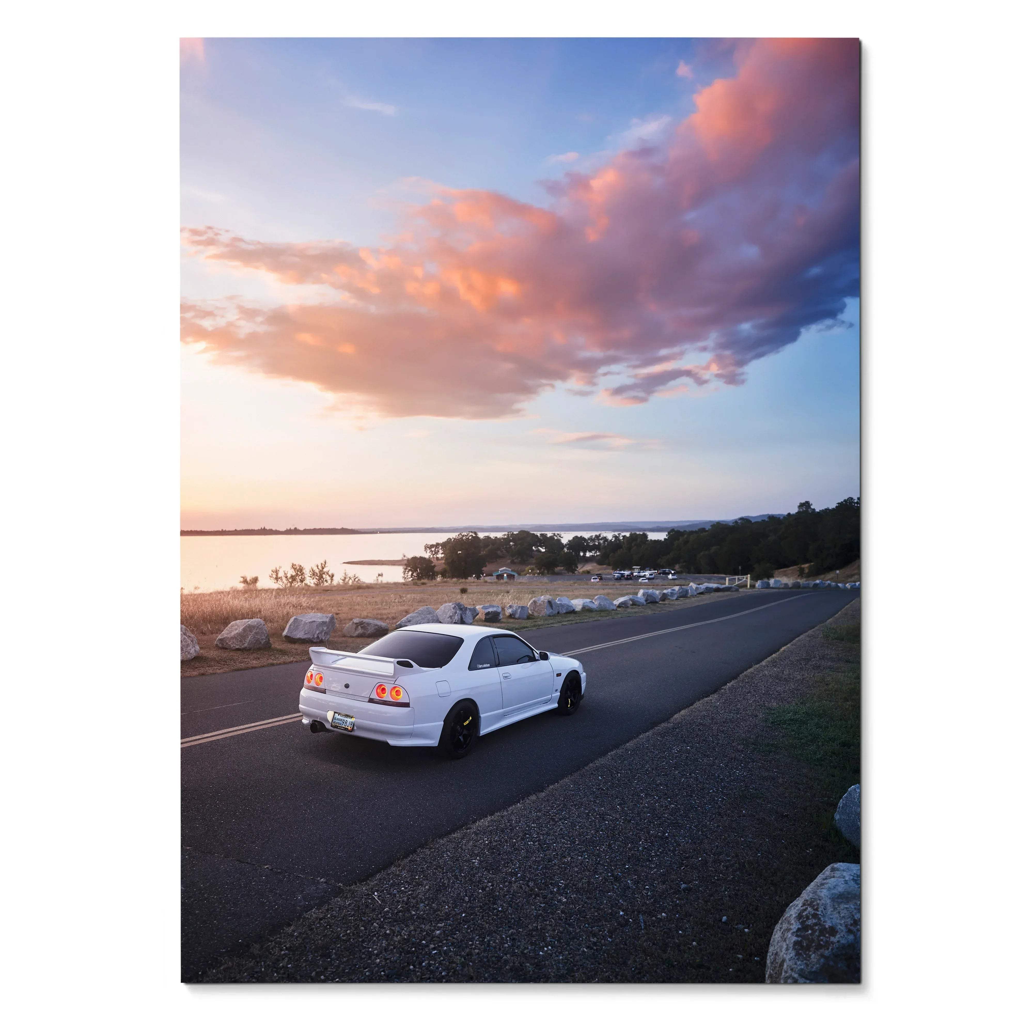 Nissan R33 GTS-T driving on coastal road at sunset poster wall art with colorful sky.