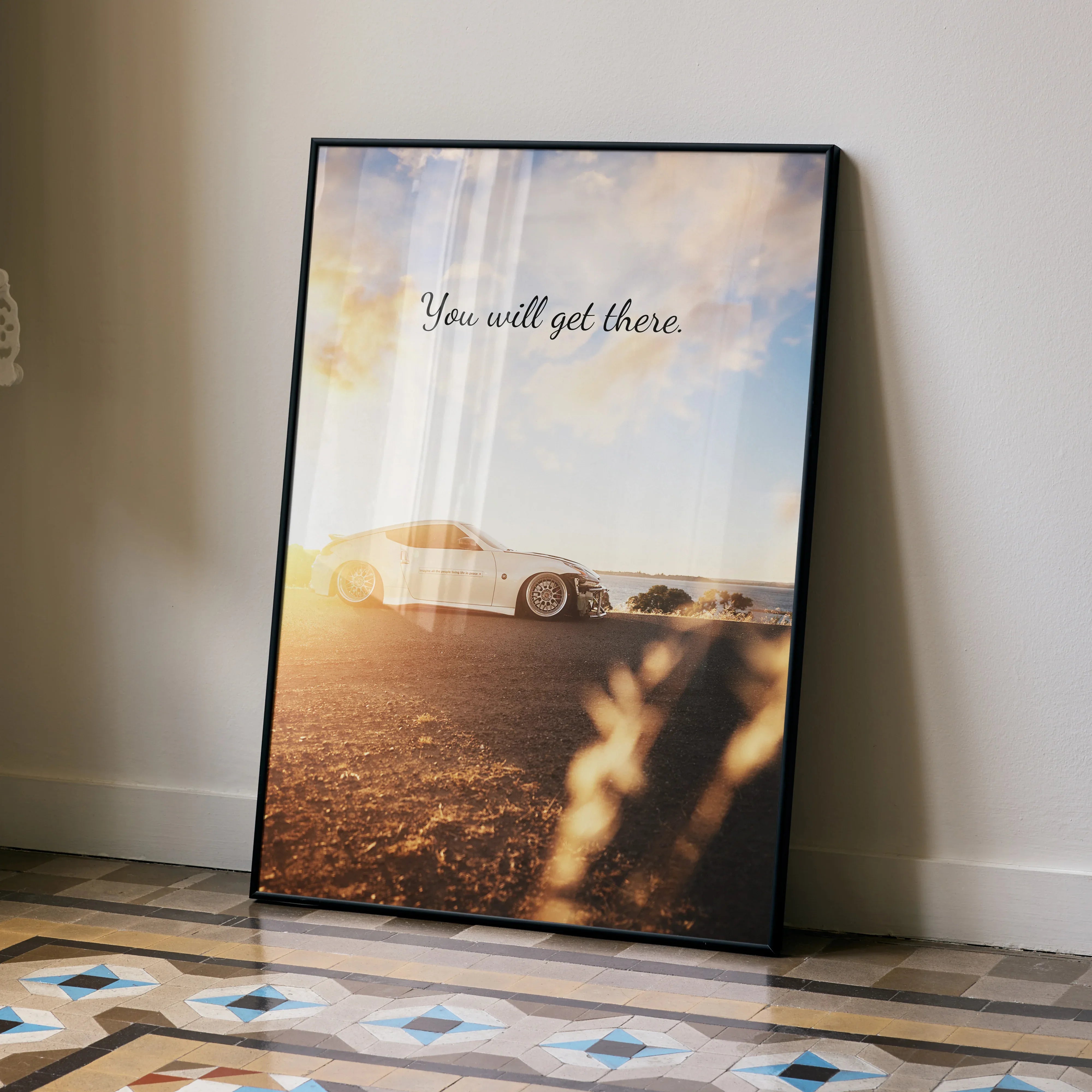 Motivational poster wall art with Nissan 370z car and "You will get there" text against a sunset sky.